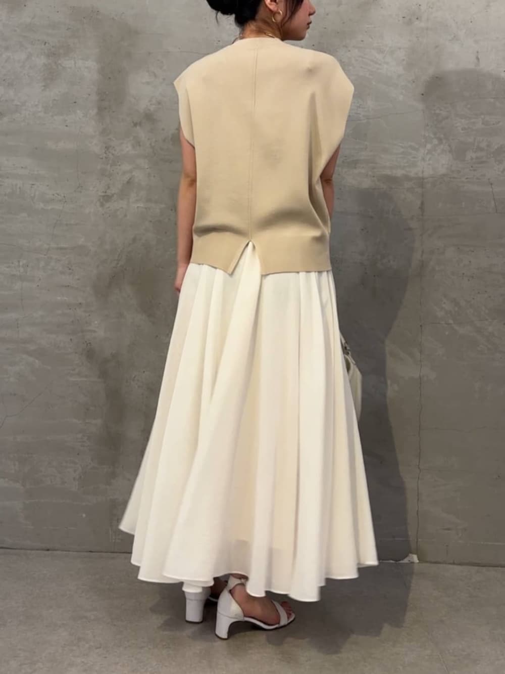 ホワイト系のスカート、ベージュ系のカーディガン/ボレロを着用したレディースの春コーディネートの4枚目の写真