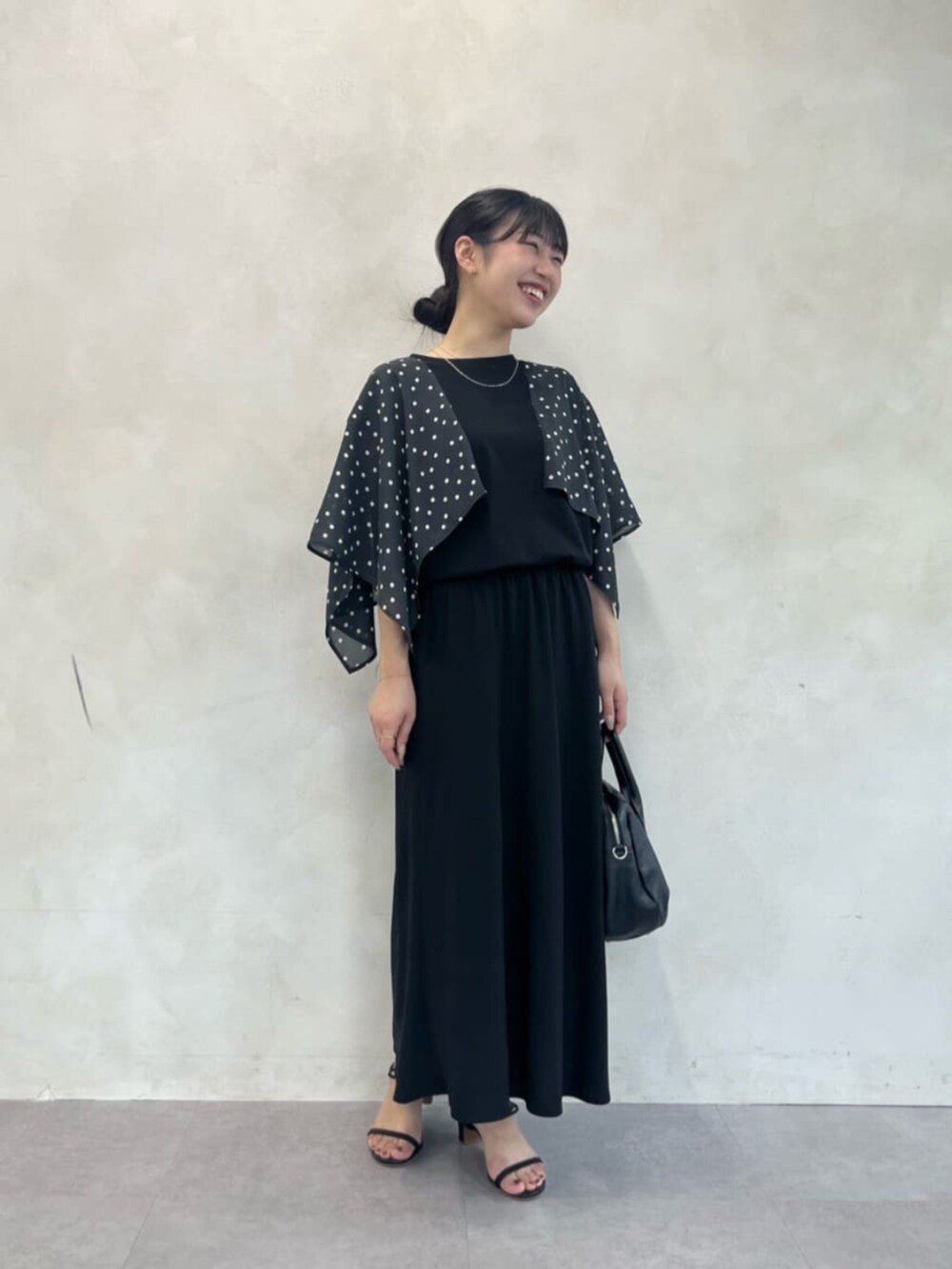 ブラック系のスカート、ブラック系のTシャツ/カットソーを着用したレディースの夏コーディネートの6枚目の写真