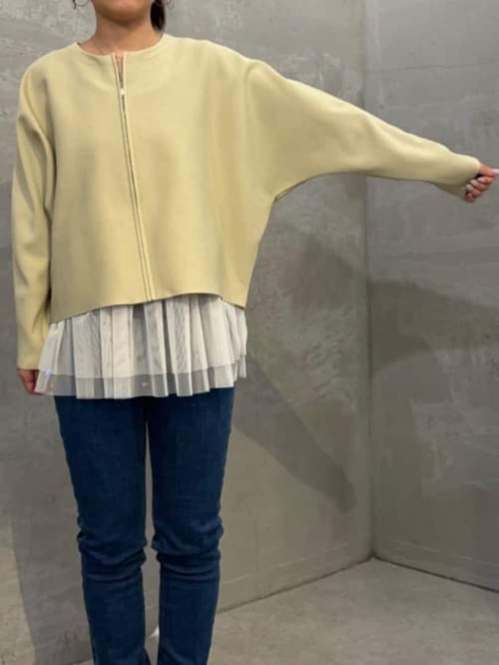 ホワイト系のキャミソール、ブルー系のデニムパンツ、ベージュ系のカーディガン/ボレロを着用したレディースの秋コーディネートの7枚目の写真