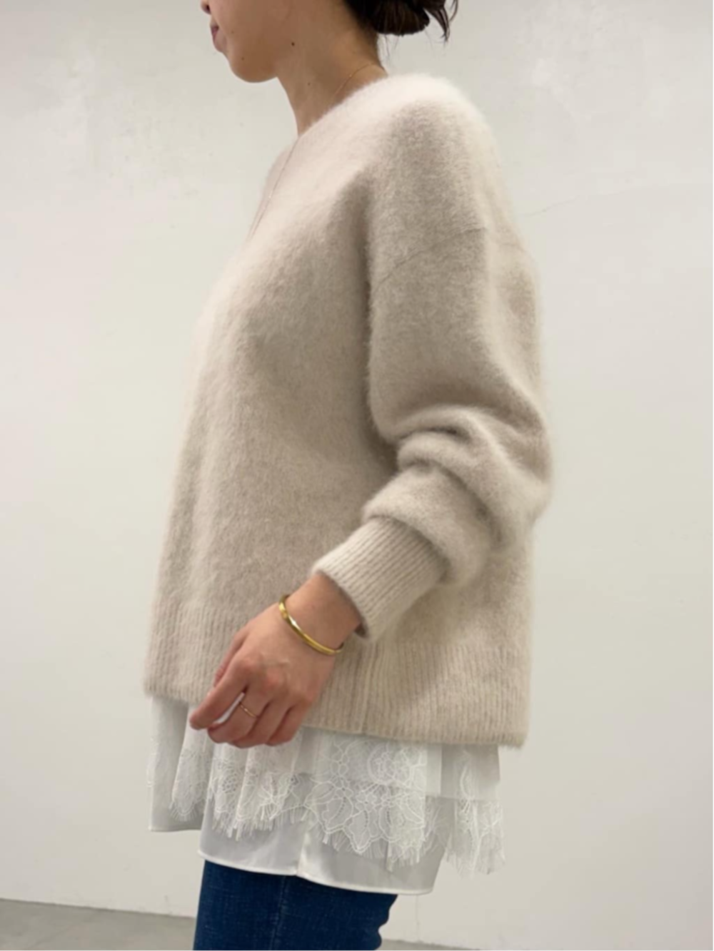 ブルー系のデニムパンツ、ホワイト系のタンクトップ、ホワイト系のニット/セーターを着用したレディースの秋コーディネートの6枚目の写真
