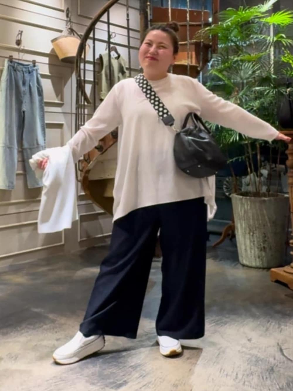 ホワイト系のTシャツ/カットソー、ブラック系のボストンバッグ、ホワイト系のスニーカーを着用したレディースの春コーディネートの3枚目の写真