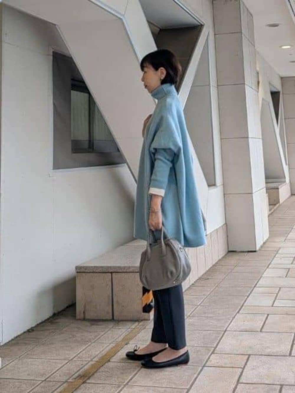 ブラック系のその他パンツ、グレー系のトートバッグ、グリーン系のニット/セーターを着用したレディースの秋コーディネートの3枚目の写真