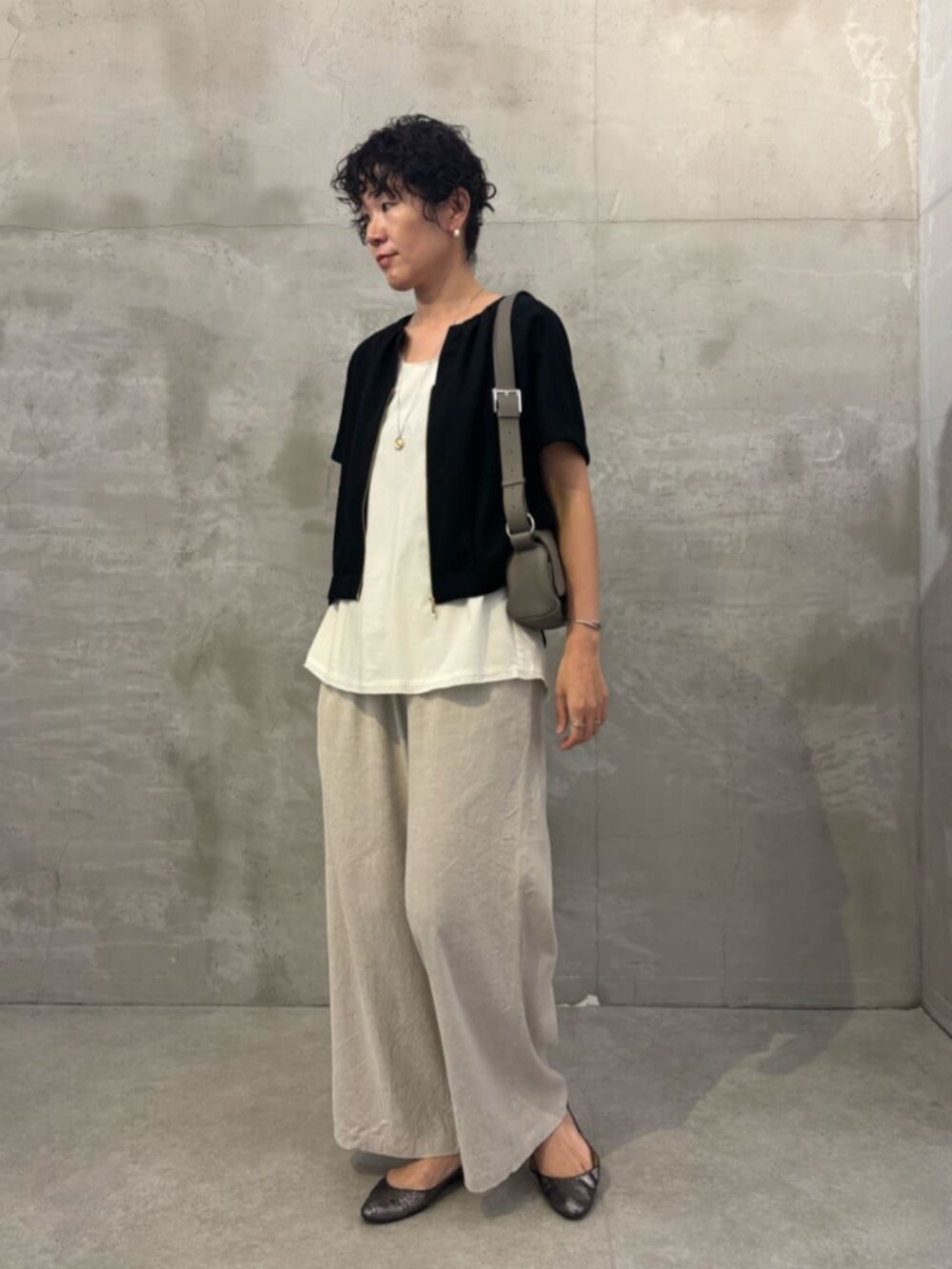 ベージュ系のその他パンツ、ホワイト系のシャツ/ブラウス、ブラック系のベストを着用したレディースの春コーディネートの2枚目の写真