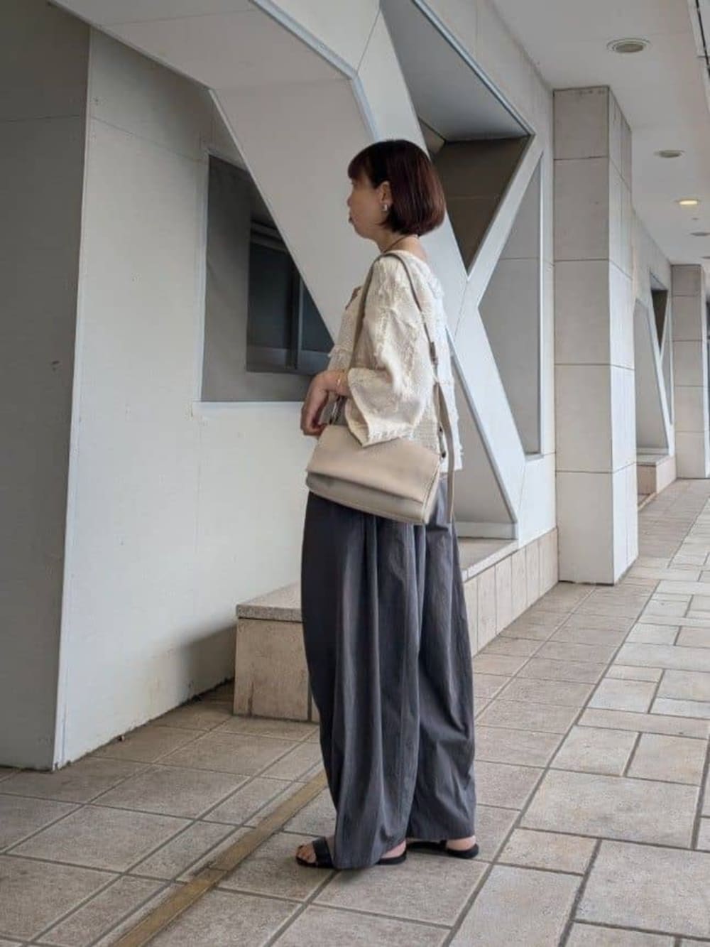ベージュ系のショルダーバッグ、グレー系のその他パンツ、ホワイト系のシャツ/ブラウスを着用したレディースの冬コーディネートの4枚目の写真