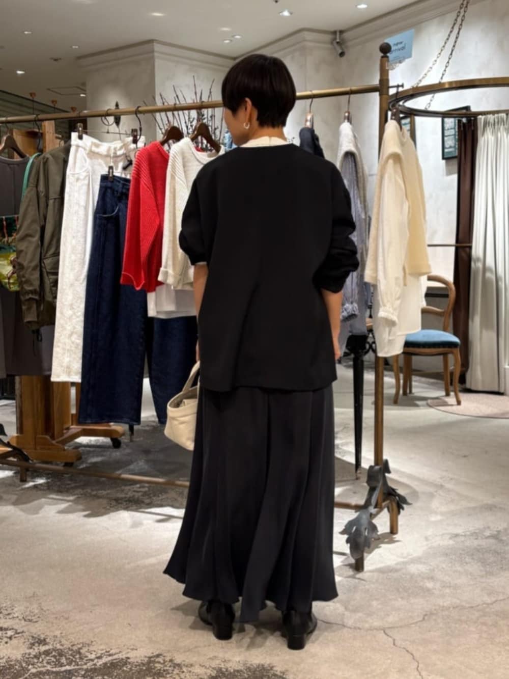 ブラック系のスカート、ベージュ系のトートバッグ、ホワイト系のシャツ/ブラウスを着用したレディースの冬コーディネートの3枚目の写真