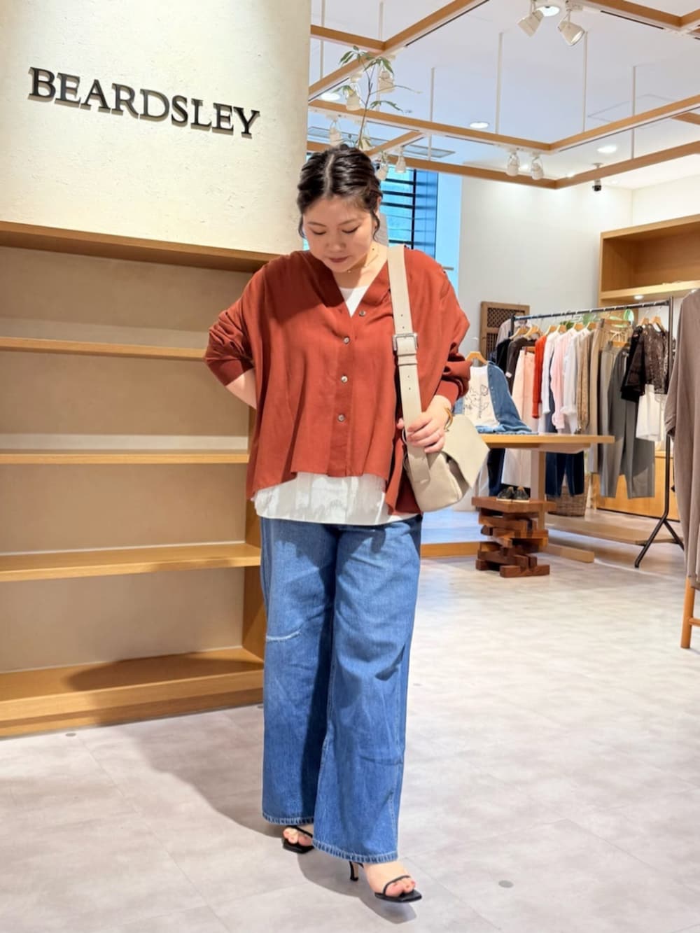 ベージュ系のショルダーバッグ、ブルー系のその他パンツ、レッド系のシャツ/ブラウスを着用したレディースの春コーディネートの2枚目の写真