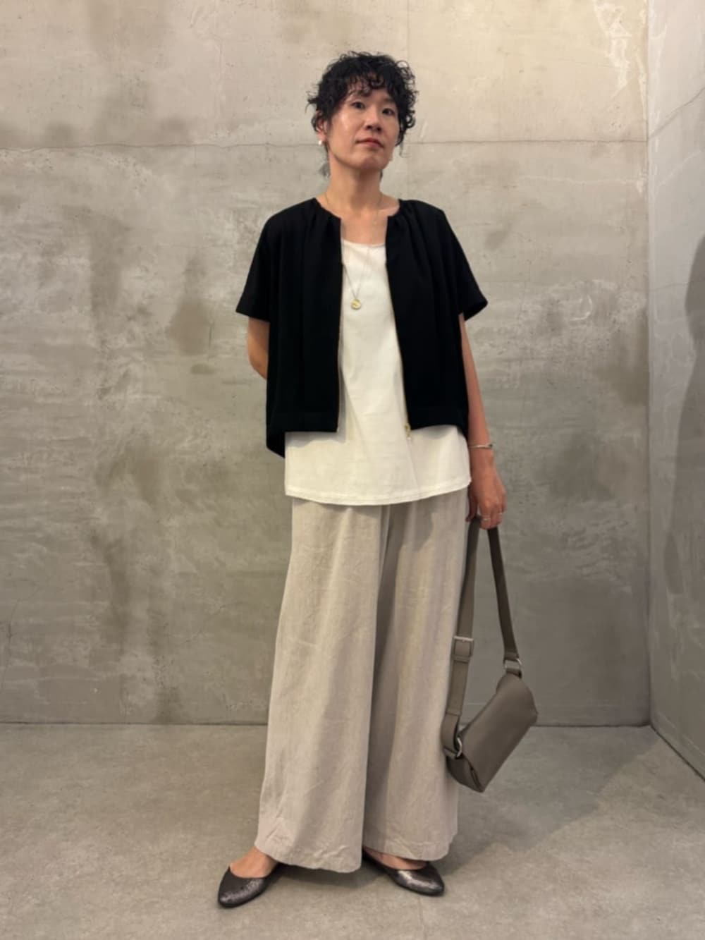 ベージュ系のその他パンツ、ホワイト系のシャツ/ブラウス、ブラック系のベストを着用したレディースの春コーディネートの5枚目の写真