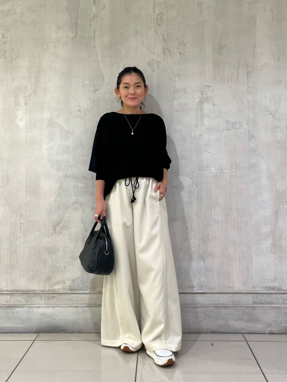 ブラック系のニット/セーター、ホワイト系のその他パンツを着用したレディースの冬コーディネートの3枚目の写真