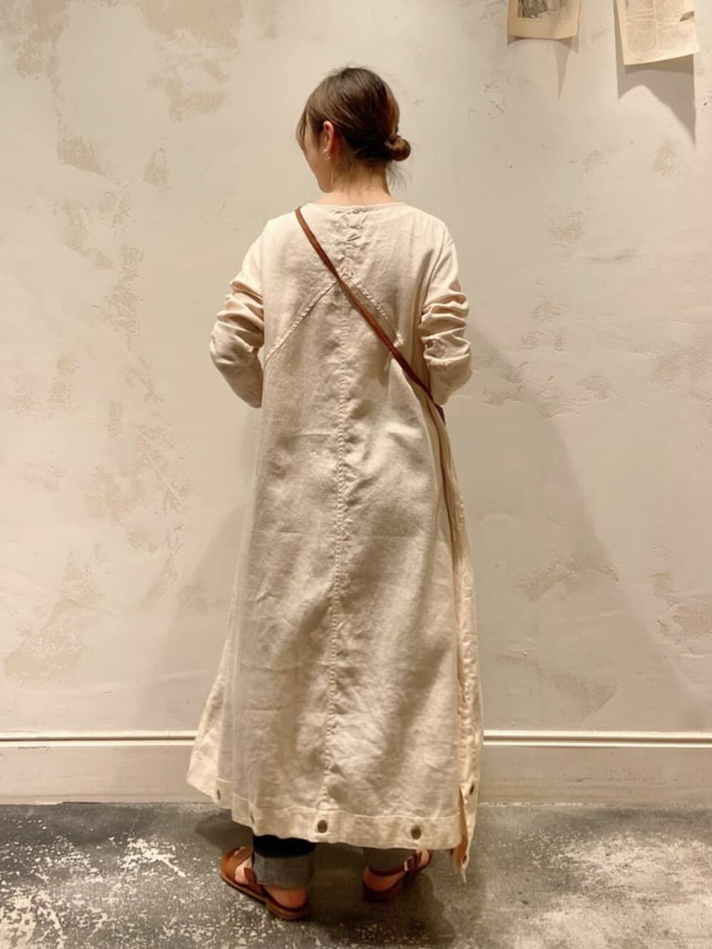 ホワイト系のワンピース、イエロー系のトートバッグ、ブルー系のデニムパンツを着用したレディースの春コーディネートの3枚目の写真