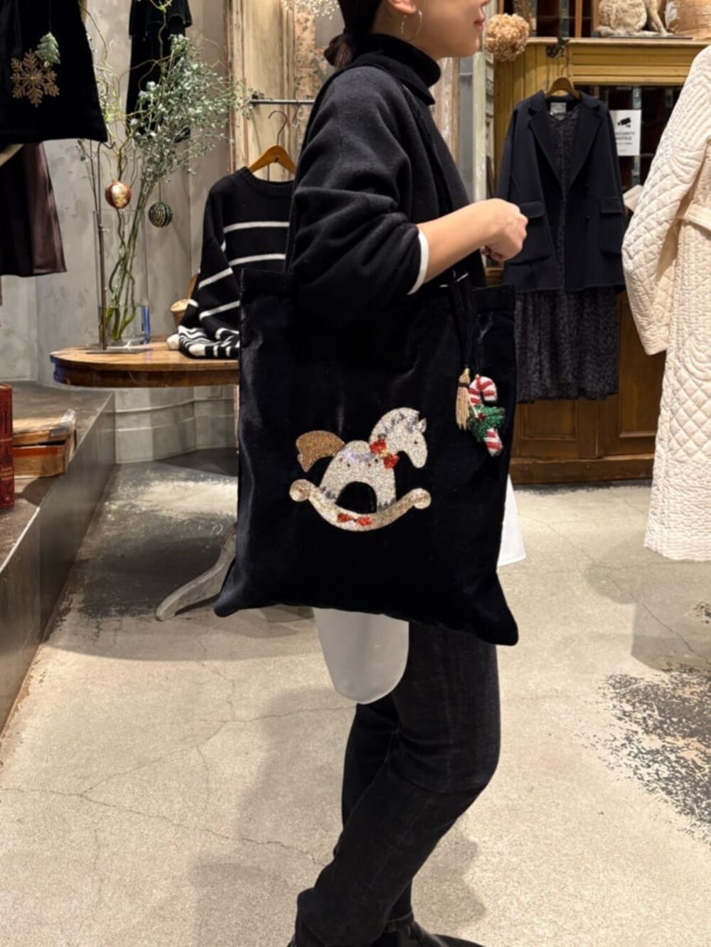 ブラック系のニット/セーター、ブラック系のデニムパンツ、ホワイト系のシャツ/ブラウスを着用したレディースの冬コーディネートの5枚目の写真