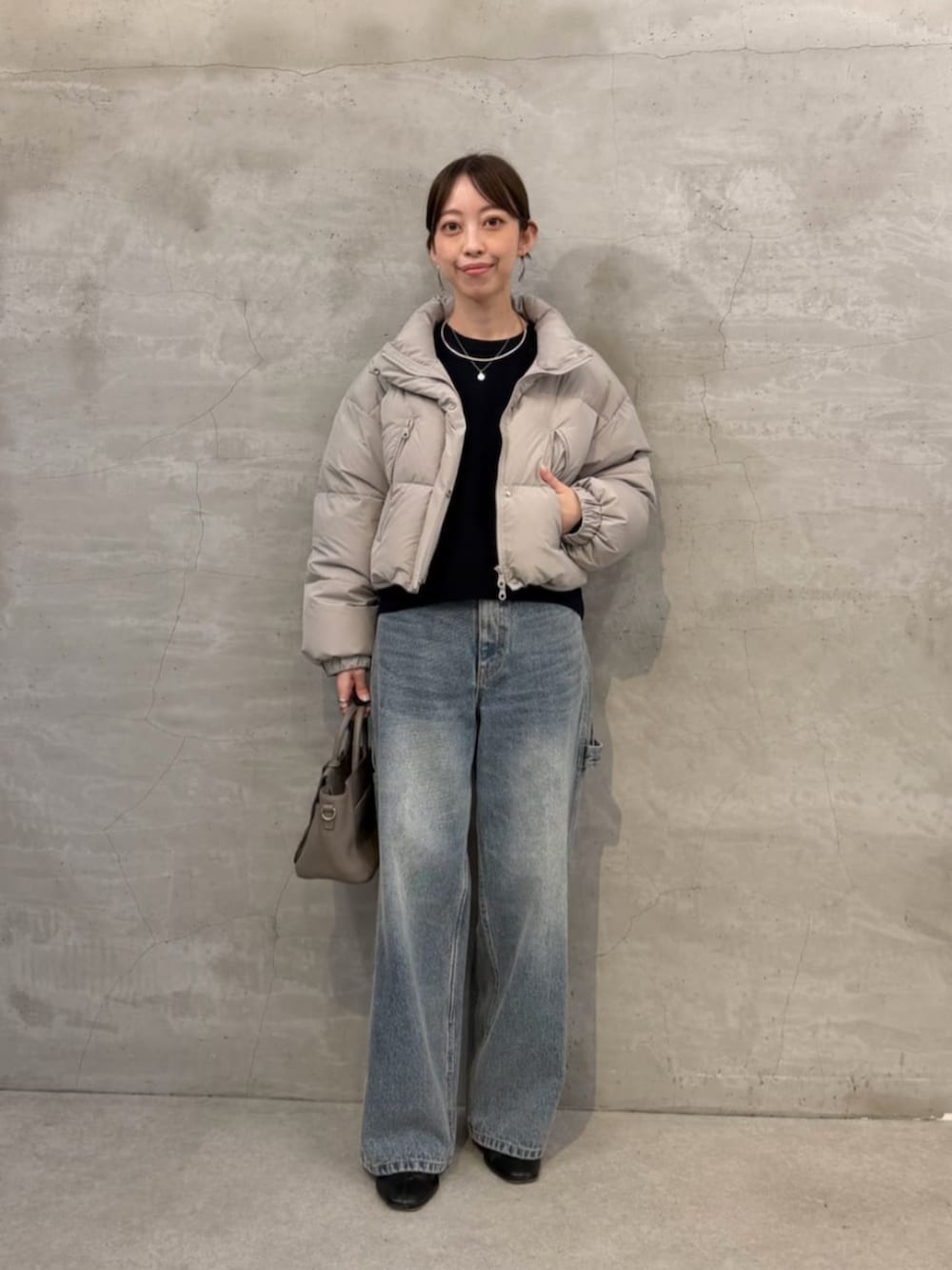 ブルー系のニット/セーター、ブルー系のデニムパンツ、グレー系のダウンジャケット/コートを着用したレディースの秋コーディネートの2枚目の写真