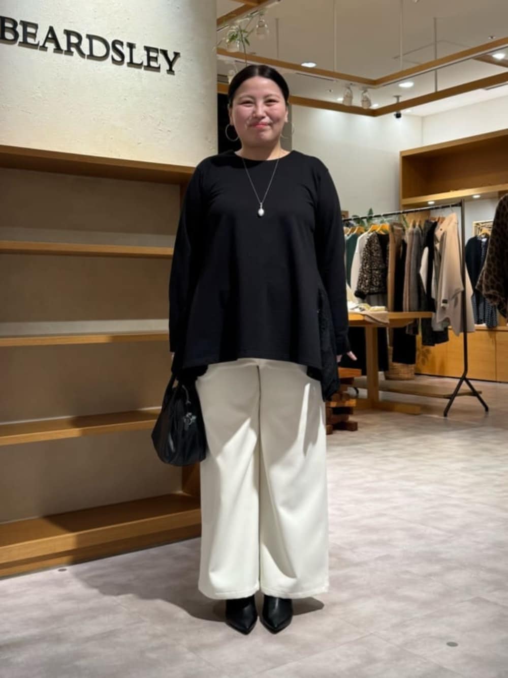 ホワイト系のその他パンツ、ブラック系のTシャツ/カットソーを着用したレディースの冬コーディネートの2枚目の写真