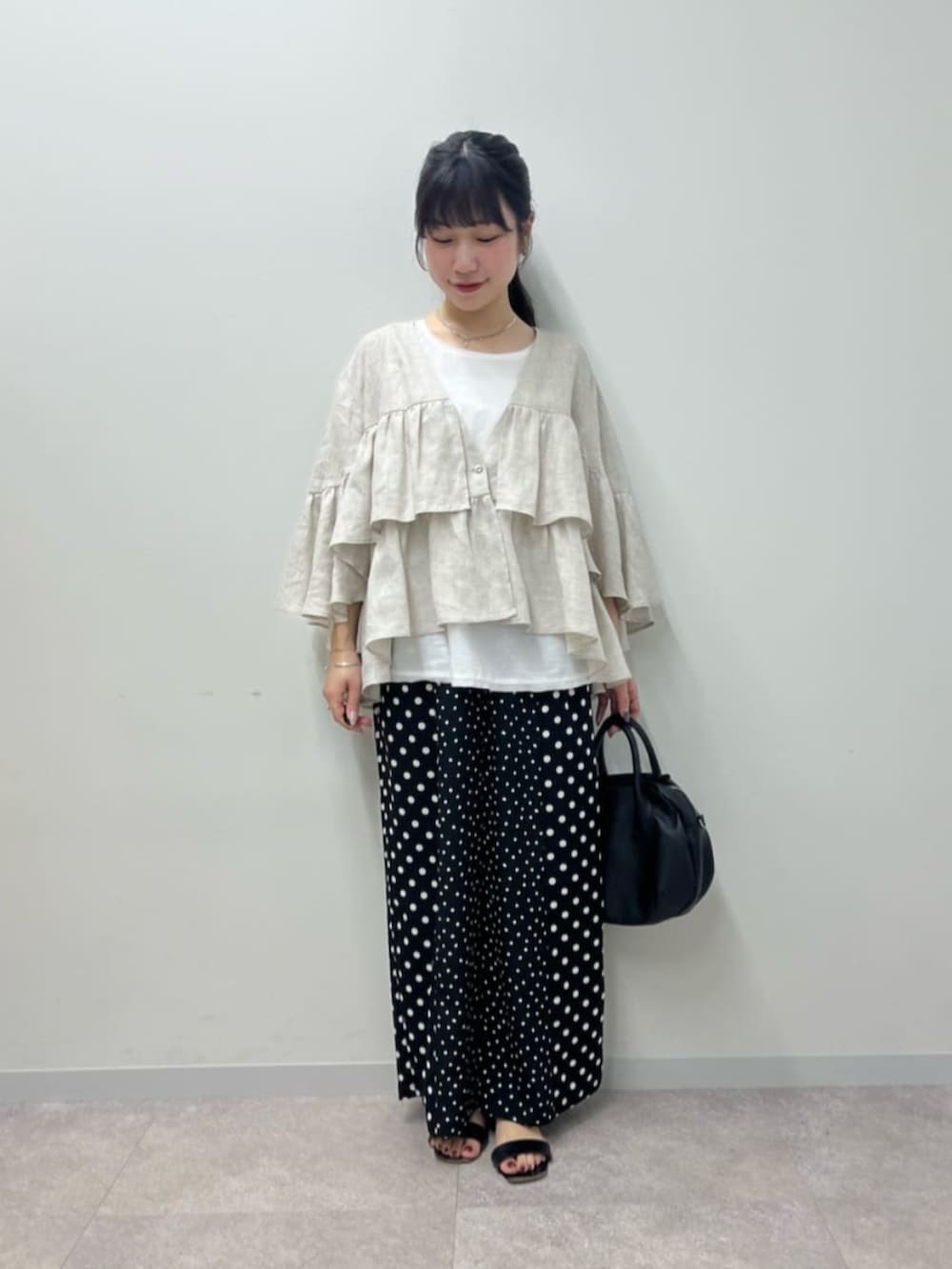 ブラック系のボストンバッグ、ホワイト系のシャツ/ブラウス、ブラック系のその他パンツを着用したレディースの春コーディネートの3枚目の写真