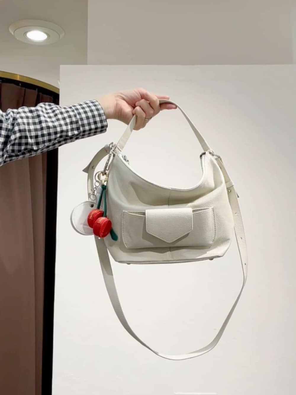 ブルー系のデニムパンツ、ブラック系のワンピース、ホワイト系のトートバッグを着用したレディースの春コーディネートの9枚目の写真