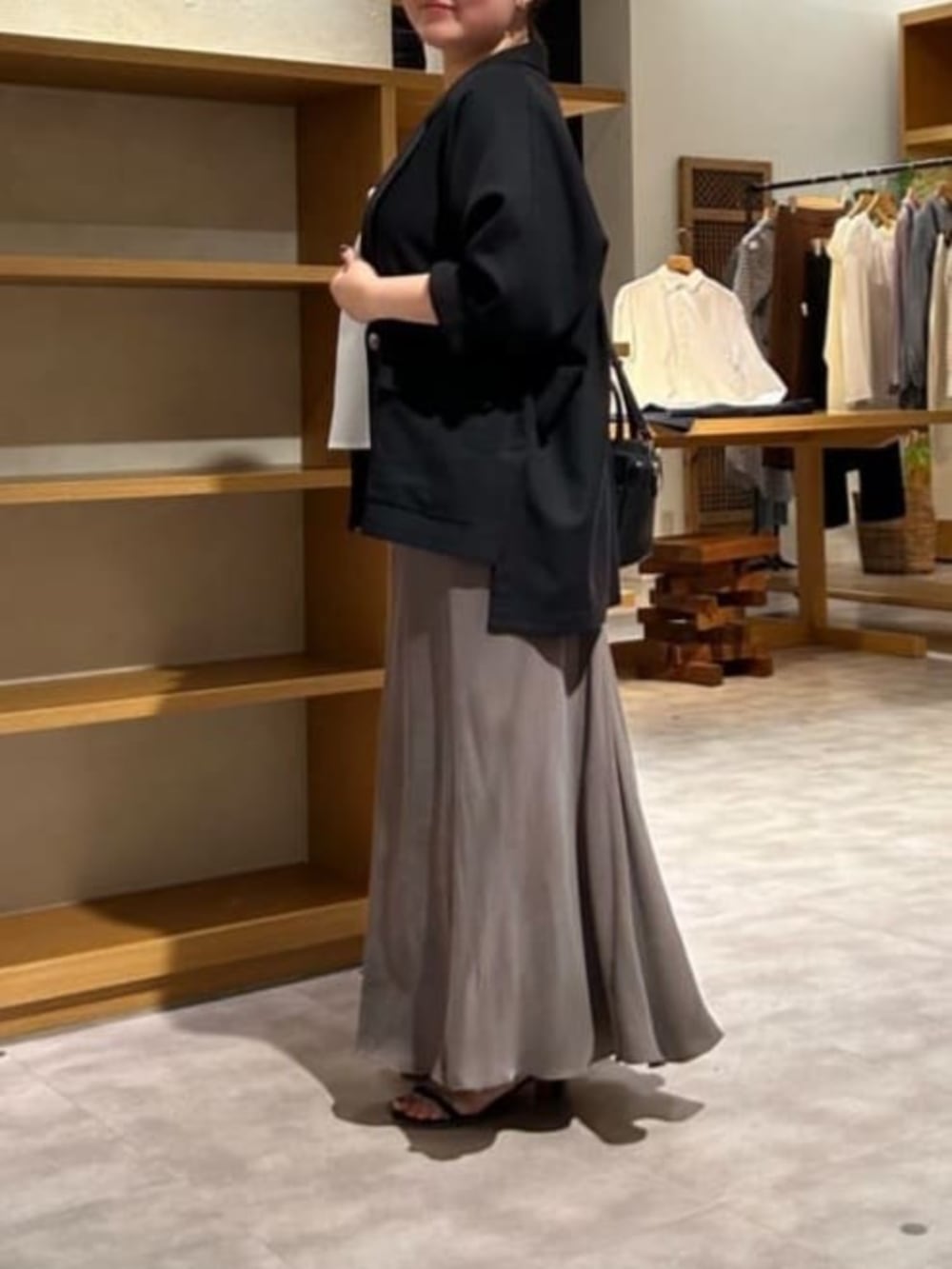 グリーン系のスカート、ブラック系のテーラードジャケット、ホワイト系のシャツ/ブラウスを着用したレディースの春コーディネートの5枚目の写真