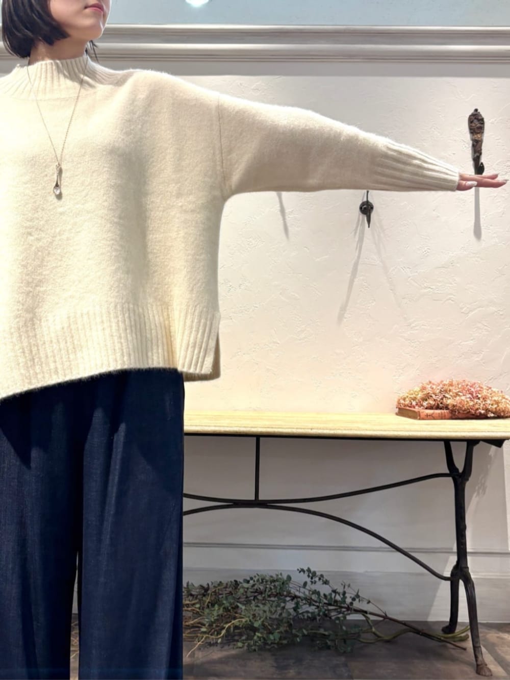 ブルー系のその他パンツ、グリーン系のハンドバッグ、ホワイト系のニット/セーターを着用したレディースの冬コーディネートの8枚目の写真