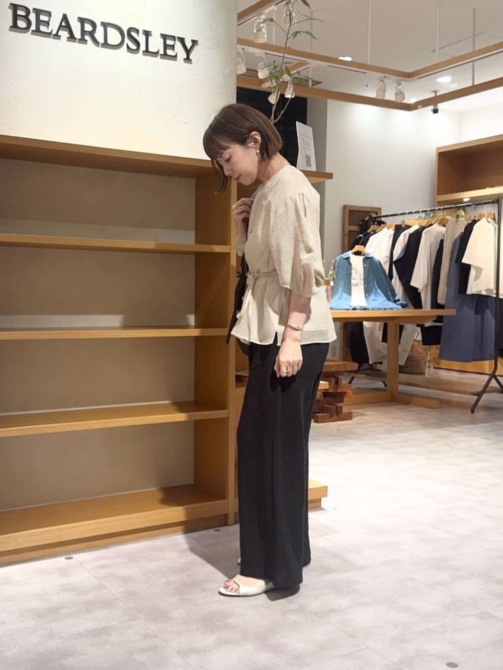 ベージュ系のシャツ/ブラウス、ブラック系のその他パンツを着用したレディースの春コーディネートの2枚目の写真