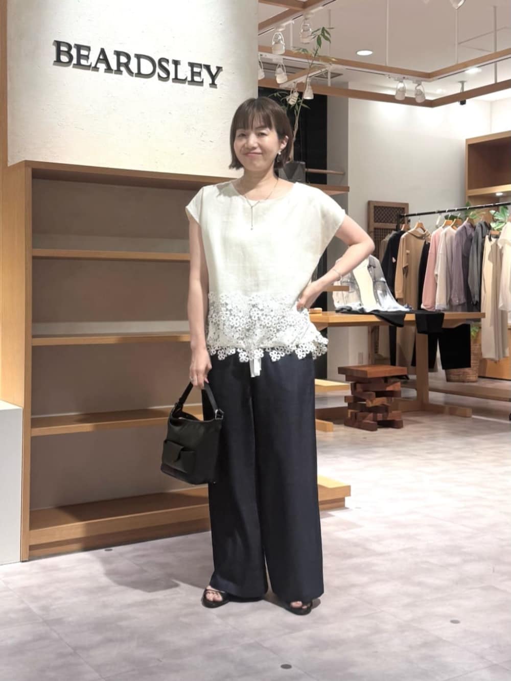 ブルー系のその他パンツ、ブラック系のトートバッグ、ホワイト系のシャツ/ブラウスを着用したレディースの春コーディネートの3枚目の写真