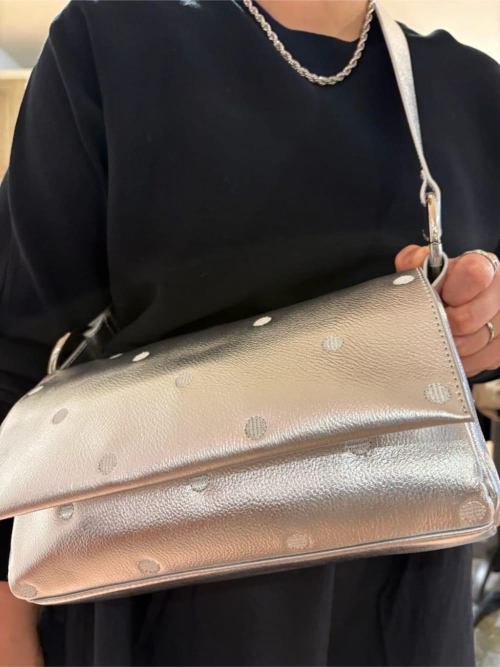 ホワイト系のスニーカー、ブラック系のワンピース、シルバー系のショルダーバッグを着用したレディースの冬コーディネートの5枚目の写真