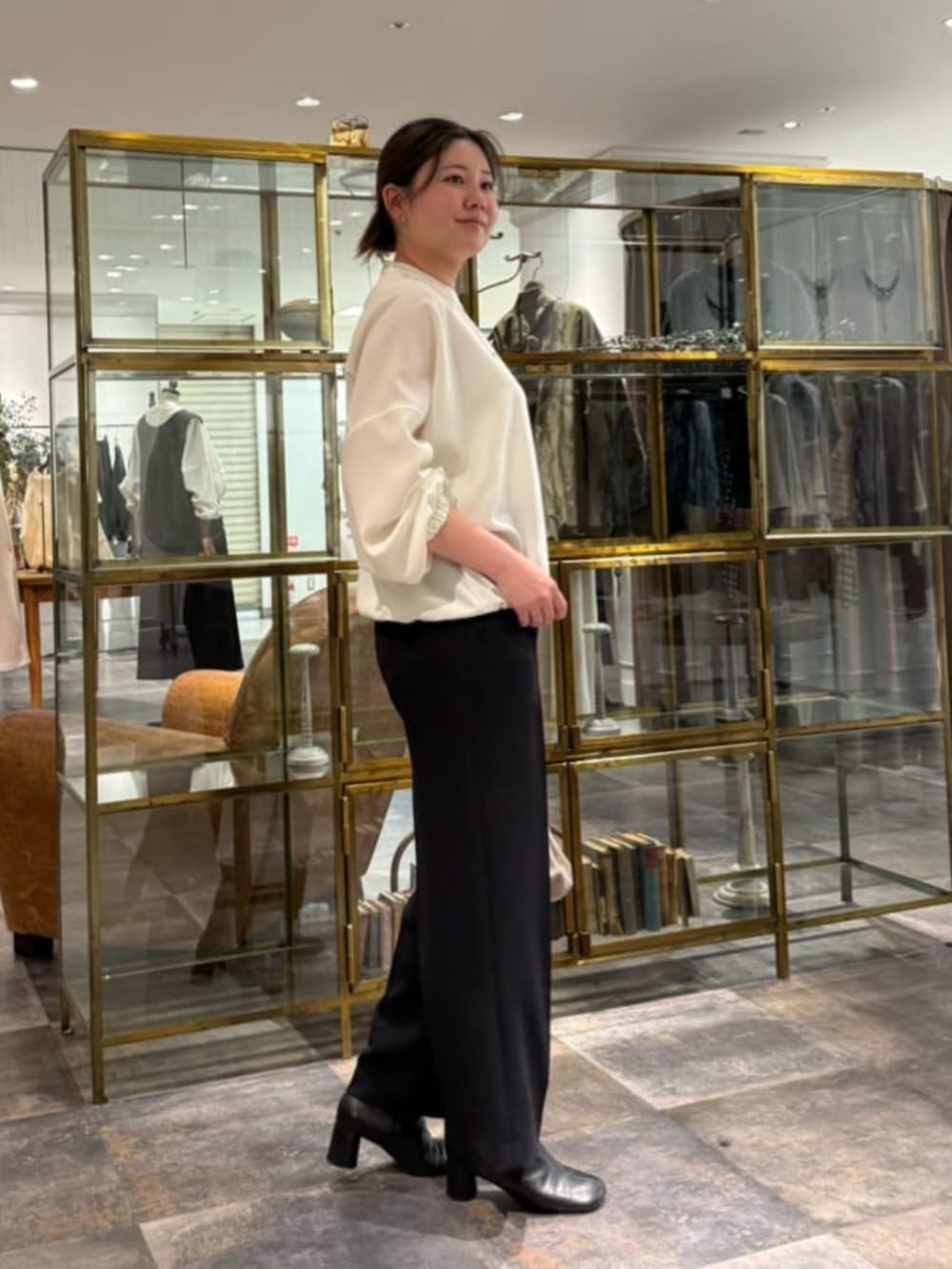 ベージュ系のショルダーバッグ、ホワイト系のシャツ/ブラウス、ブラック系のその他パンツを着用したレディースの冬コーディネートの2枚目の写真