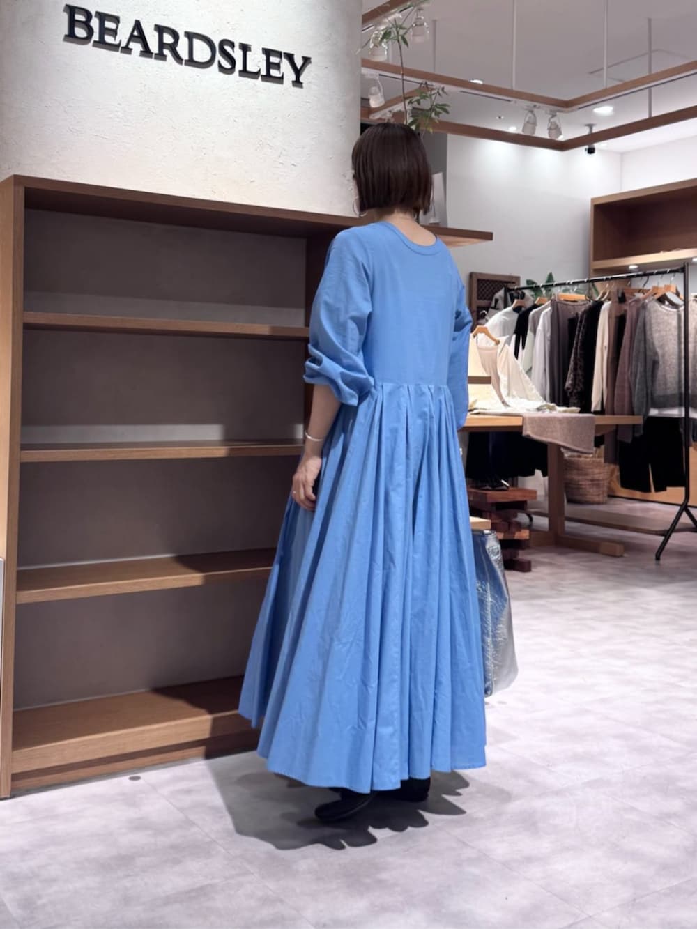 ブルー系のワンピース、ブラック系のトートバッグを着用したレディースの冬コーディネートの2枚目の写真