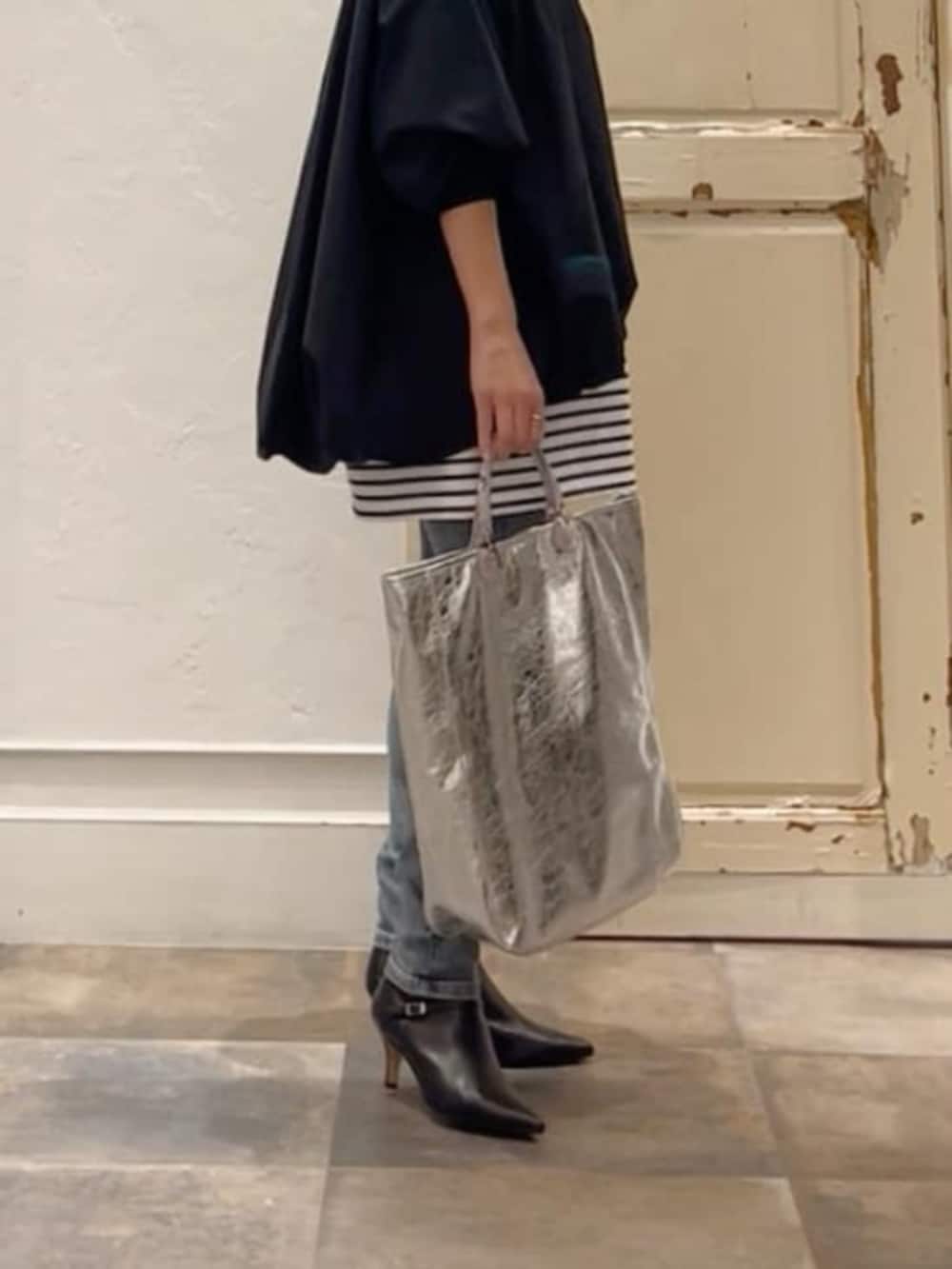 ブルー系のデニムパンツ、ブルー系のTシャツ/カットソー、ブラック系のトートバッグを着用したレディースの冬コーディネートの8枚目の写真