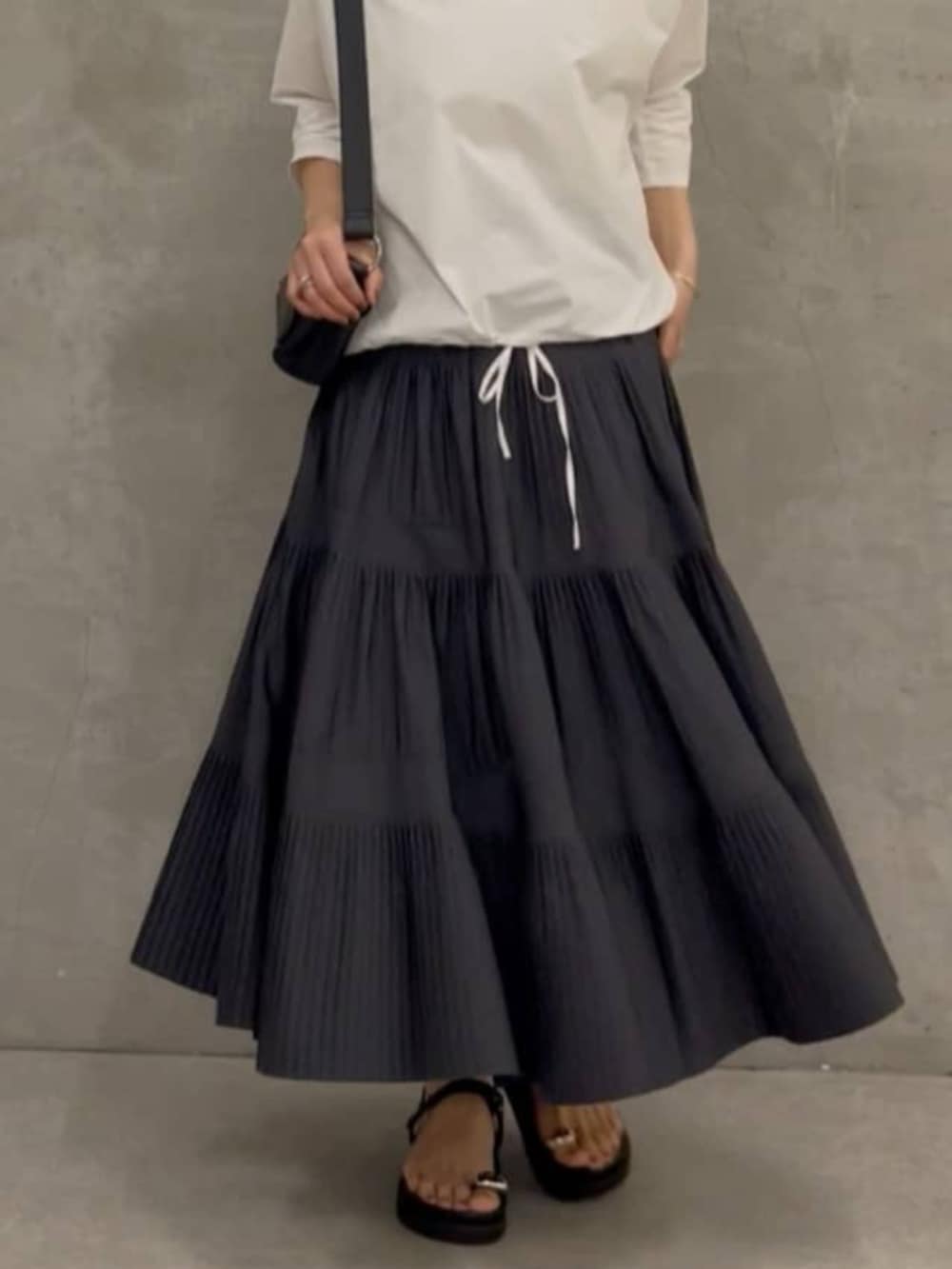 グレー系のスカート、ブラック系のショルダーバッグ、ホワイト系のシャツ/ブラウスを着用したレディースの春コーディネートの5枚目の写真