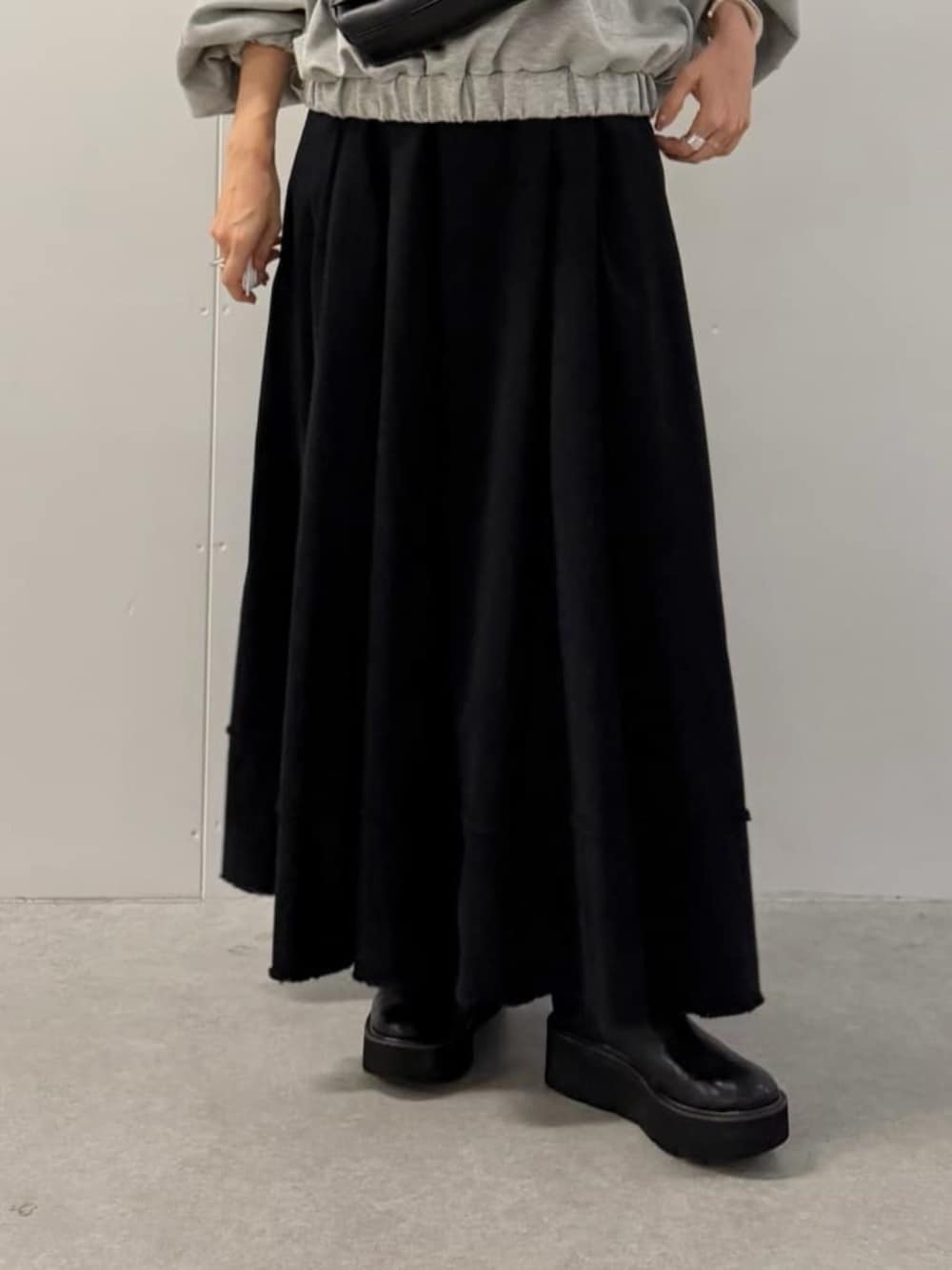 ブラック系のショルダーバッグ、ブラック系のスカート、グレー系のTシャツ/カットソーを着用したレディースの夏コーディネートの9枚目の写真