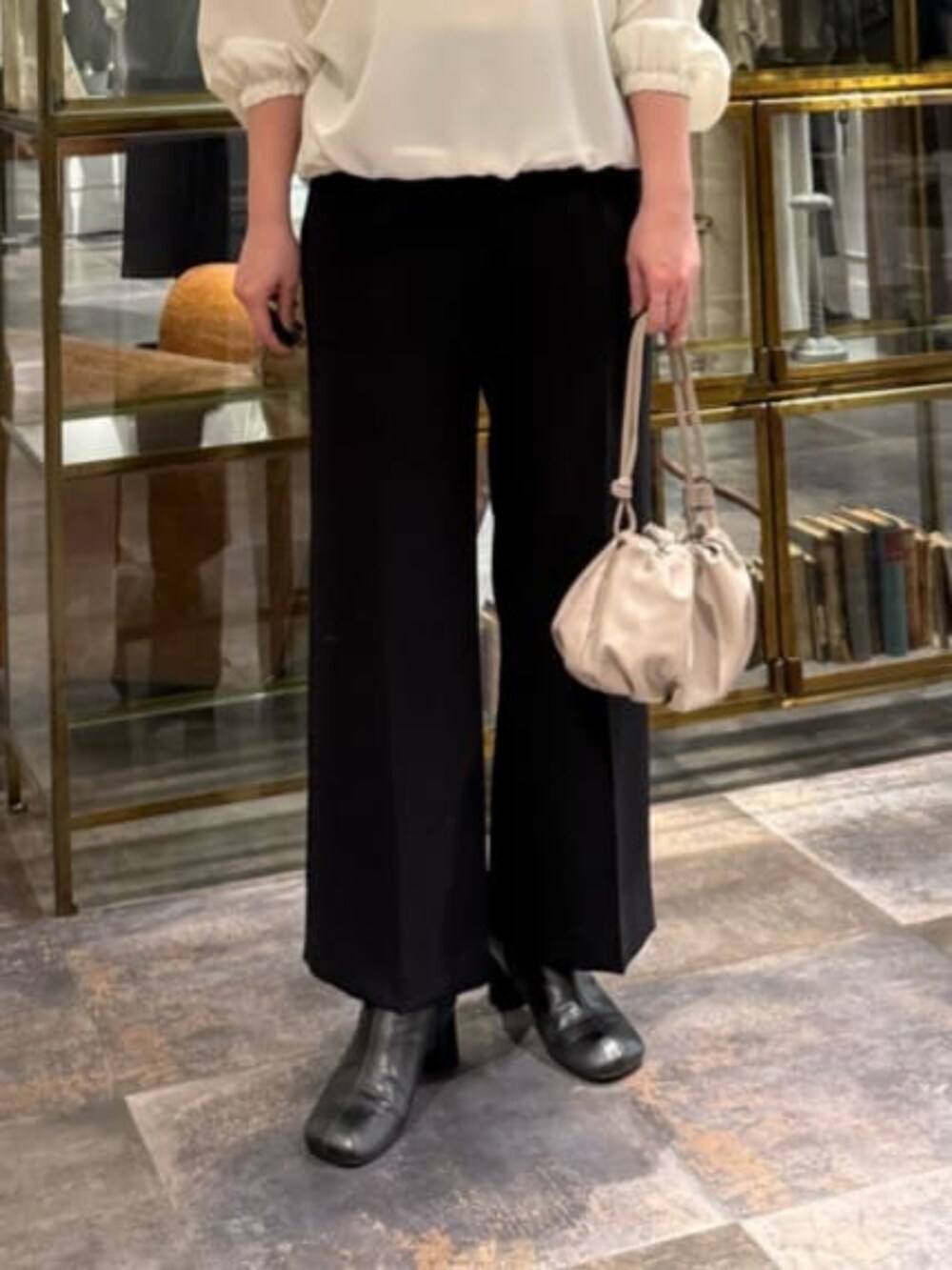 ベージュ系のショルダーバッグ、ホワイト系のシャツ/ブラウス、ブラック系のその他パンツを着用したレディースの冬コーディネートの7枚目の写真