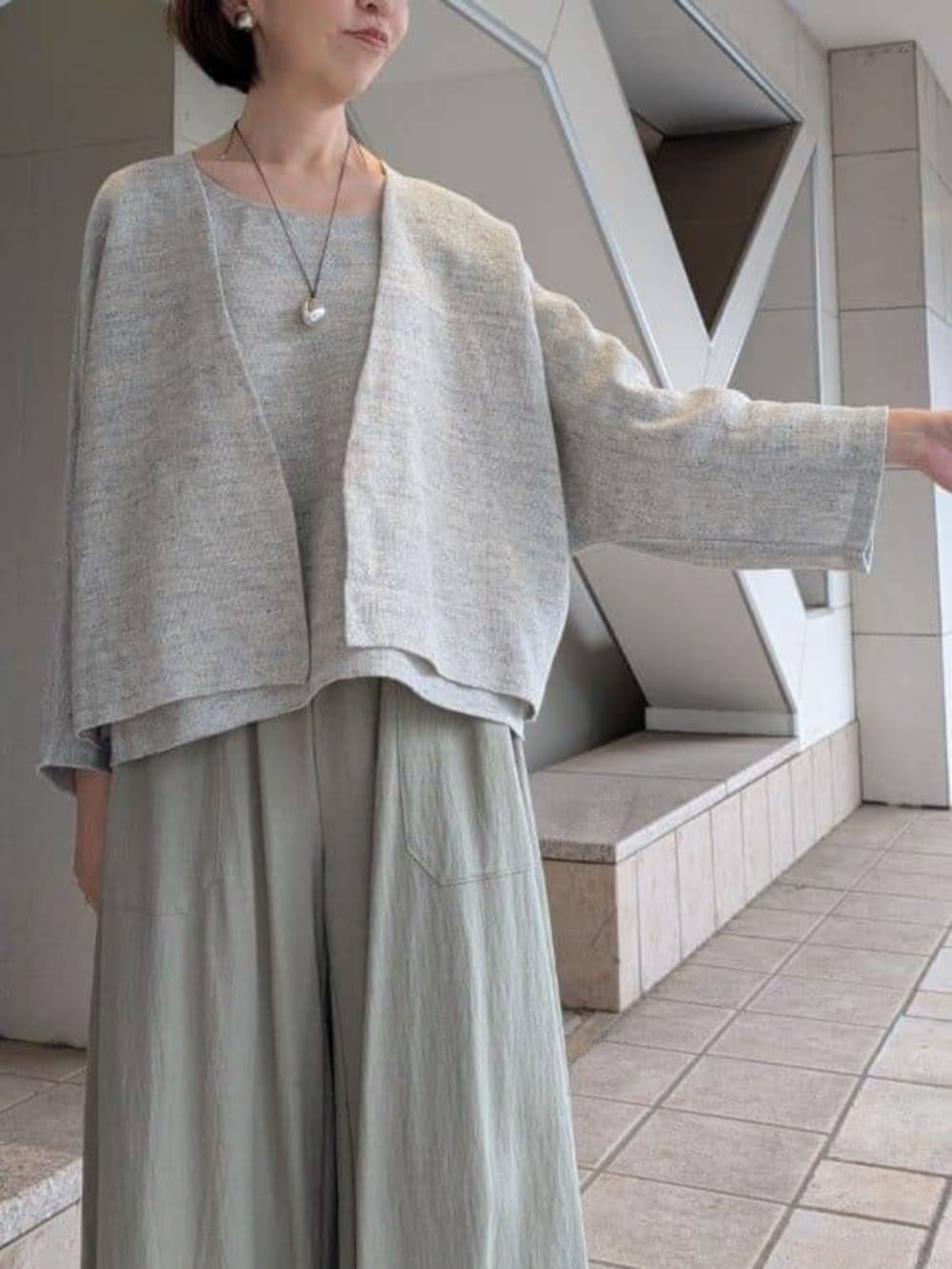 グリーン系のその他パンツ、ブラック系のサンダル、グレー系のニット/セーターを着用したレディースの冬コーディネートの5枚目の写真