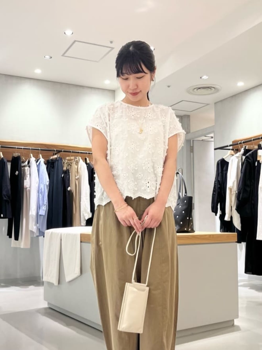 ホワイト系のショルダーバッグ、イエロー系のその他パンツ、ホワイト系のシャツ/ブラウスを着用したレディースの夏コーディネートの2枚目の写真