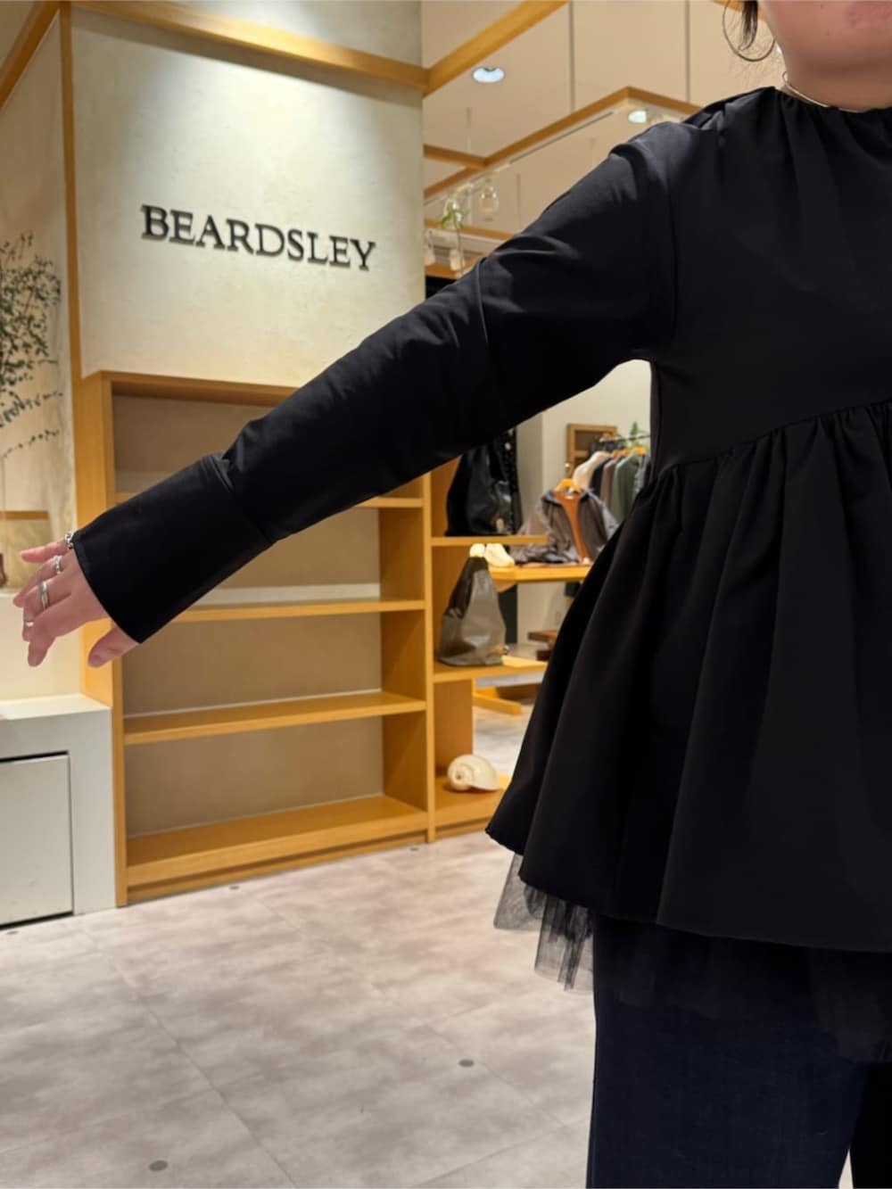 ピンク系のハンドバッグ、ブラック系のブーツ、ブラック系のブルゾンを着用したレディースの冬コーディネートの8枚目の写真