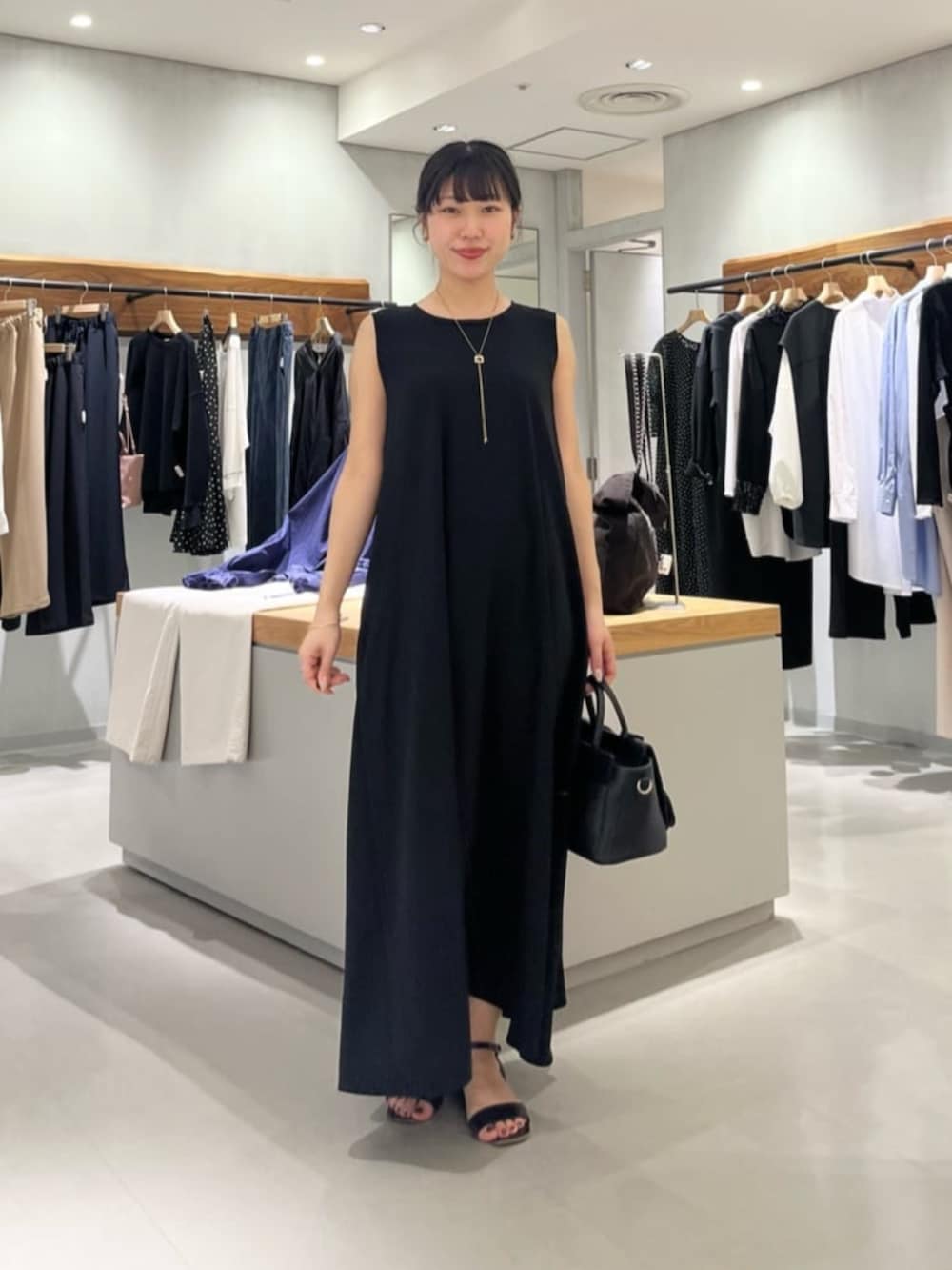 ブラック系のハンドバッグ、ブラック系のワンピースを着用したレディースの春コーディネートの4枚目の写真