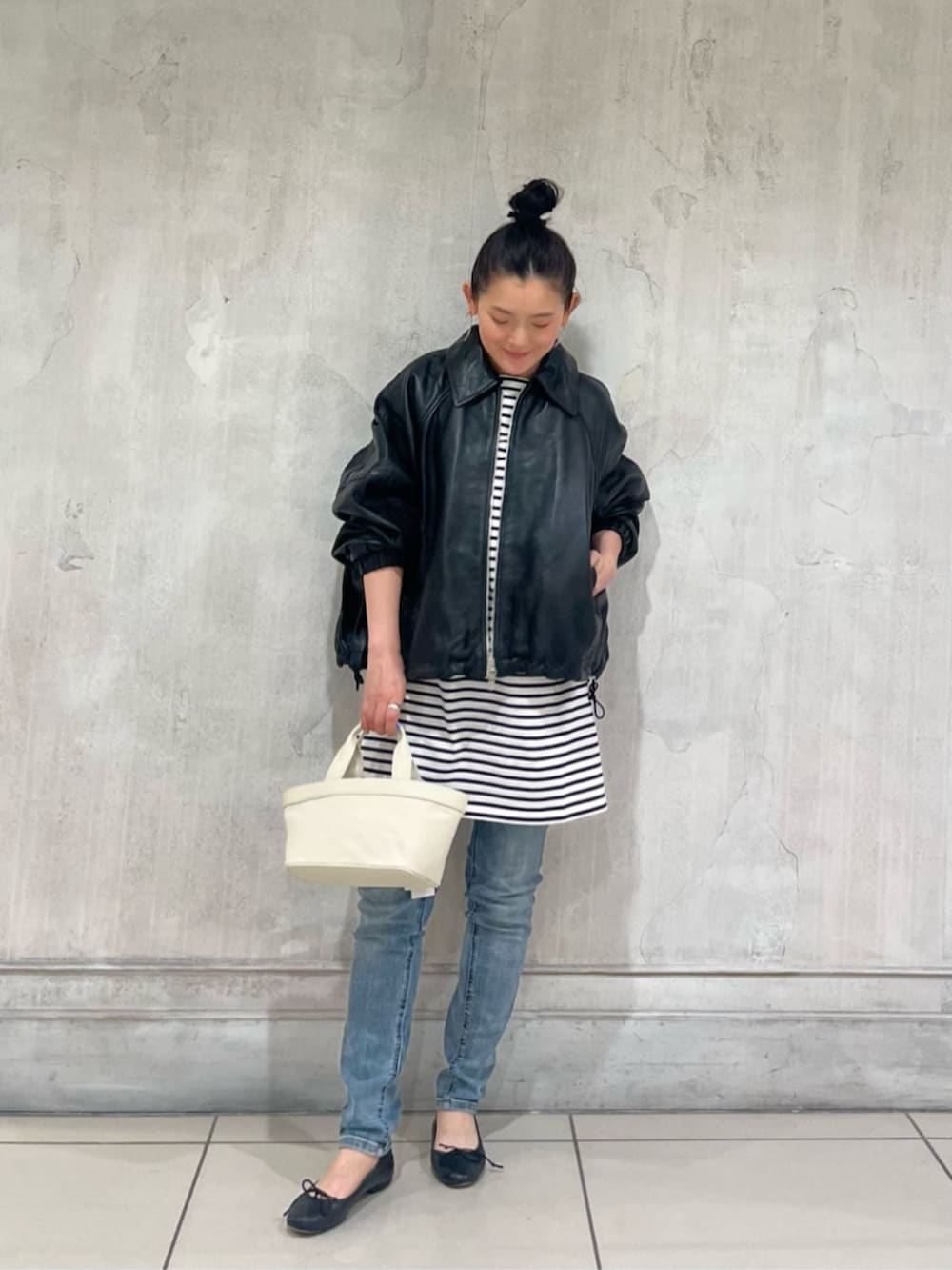 ブルー系のデニムパンツ、ブラック系のブルゾンを着用したレディースの冬コーディネートの2枚目の写真