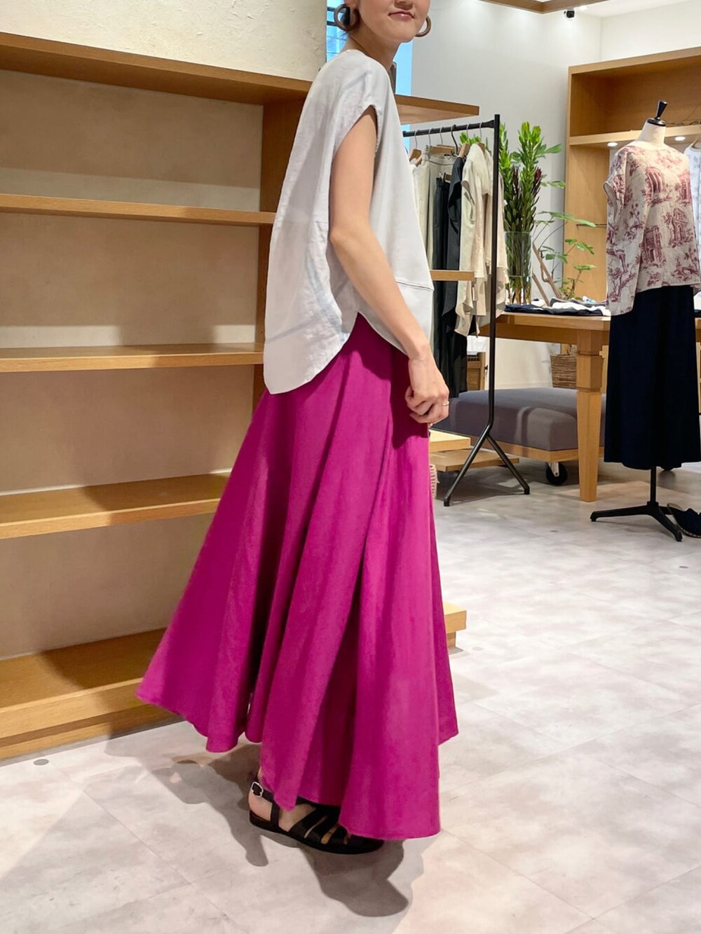 グレー系のTシャツ/カットソー、ピンク系のスカート、ベージュ系のかごバッグを着用したレディースの春コーディネートの2枚目の写真