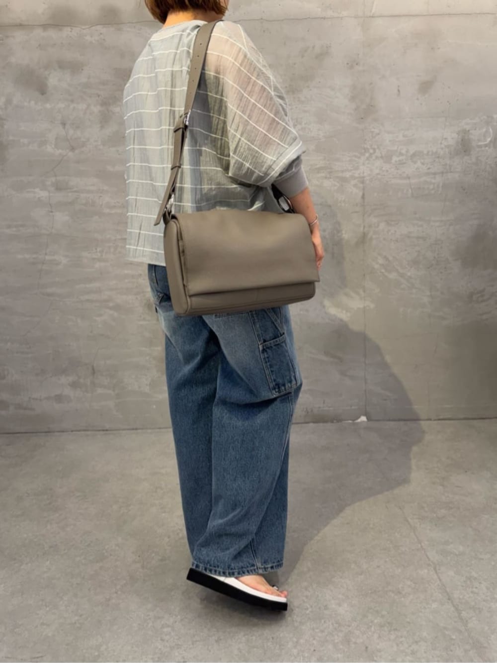 ブルー系のその他パンツ、ホワイト系のサンダル、グレー系のシャツ/ブラウスを着用したレディースの春コーディネートの6枚目の写真