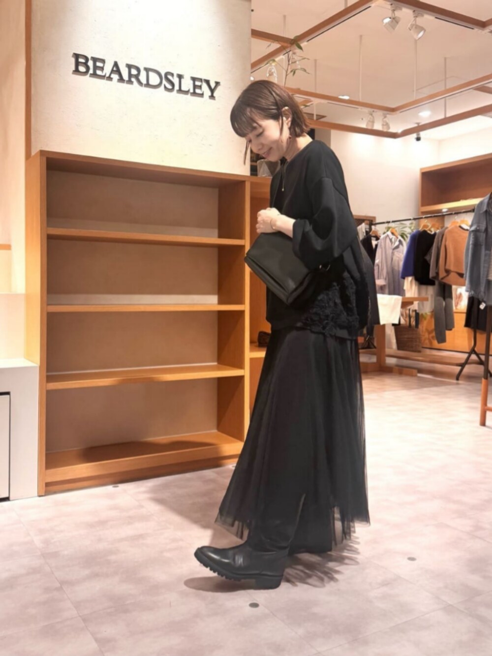 ブラック系のTシャツ/カットソー、ブラック系のスカートを着用したレディースの秋コーディネートの3枚目の写真