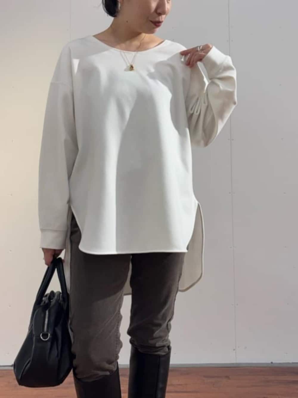 ブルー系のデニムパンツ、ブラック系のトートバッグ、ブルー系のニット/セーターを着用したレディースの秋コーディネートの7枚目の写真