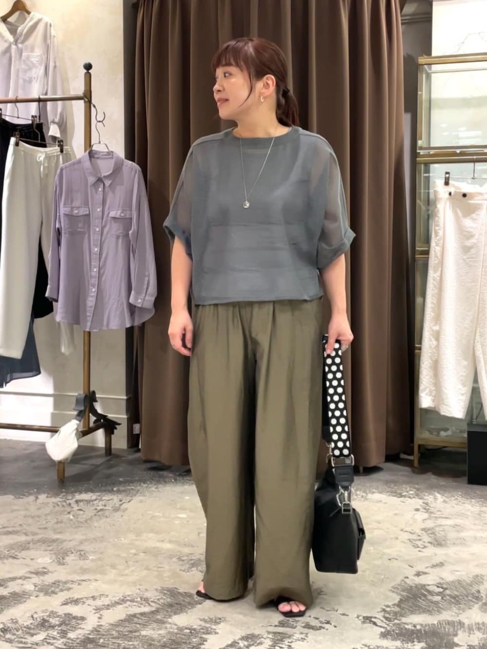 ブラック系のトートバッグ、グレー系のTシャツ/カットソー、グリーン系のその他パンツを着用したレディースの春コーディネートの2枚目の写真