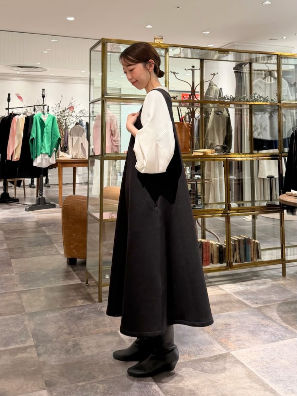 ブラック系のボストンバッグ、ホワイト系のシャツ/ブラウス、ブラック系のジャンパースカートを着用したレディースの冬コーディネートの2枚目の写真