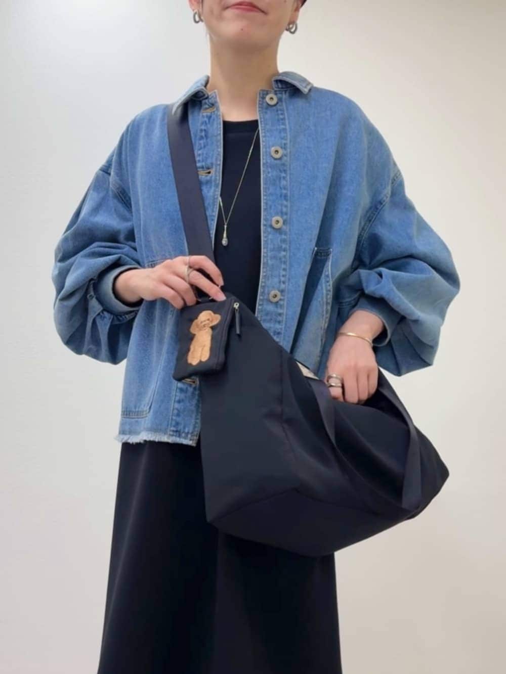 ブルー系のデニムジャケット、ブラック系のワンピース、ブラック系のトートバッグを着用したレディースの冬コーディネートの6枚目の写真