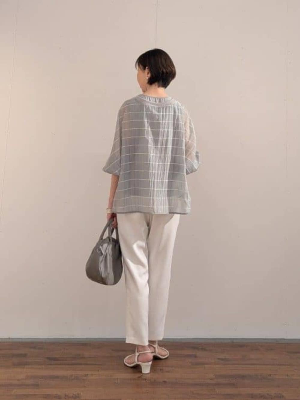 グレー系のボストンバッグ、グレー系のシャツ/ブラウス、ホワイト系のその他パンツを着用したレディースの春コーディネートの3枚目の写真