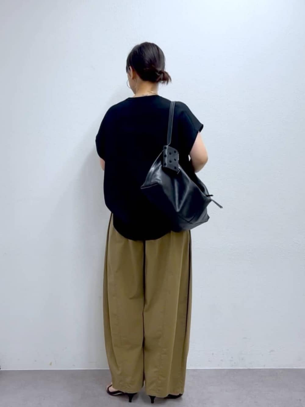 イエロー系のその他パンツ、ブラック系のニット/セーターを着用したレディースの夏コーディネートの5枚目の写真