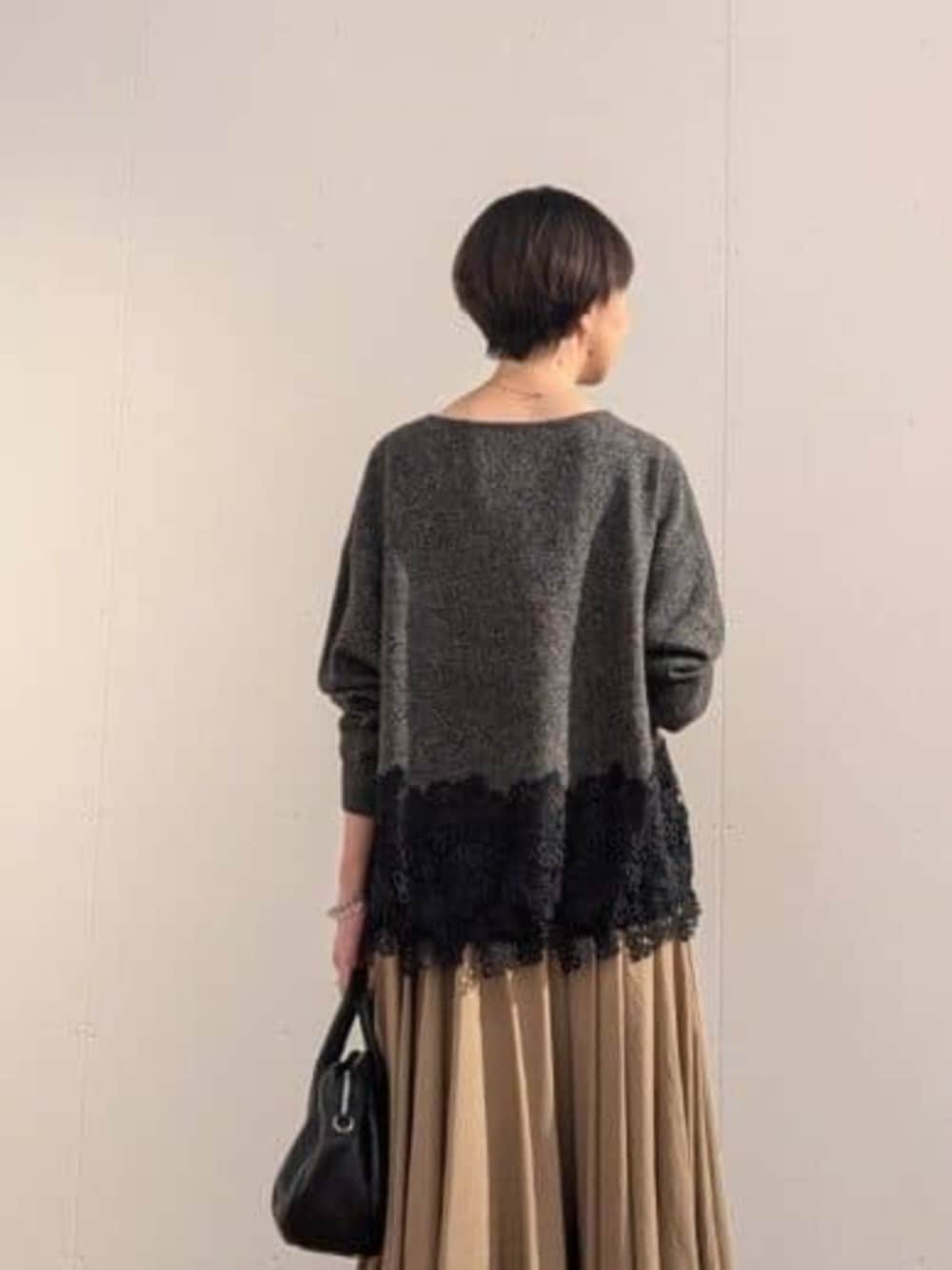 ブラック系のトートバッグ、ブラウン系のスカート、グレー系のニット/セーターを着用したレディースの秋コーディネートの4枚目の写真