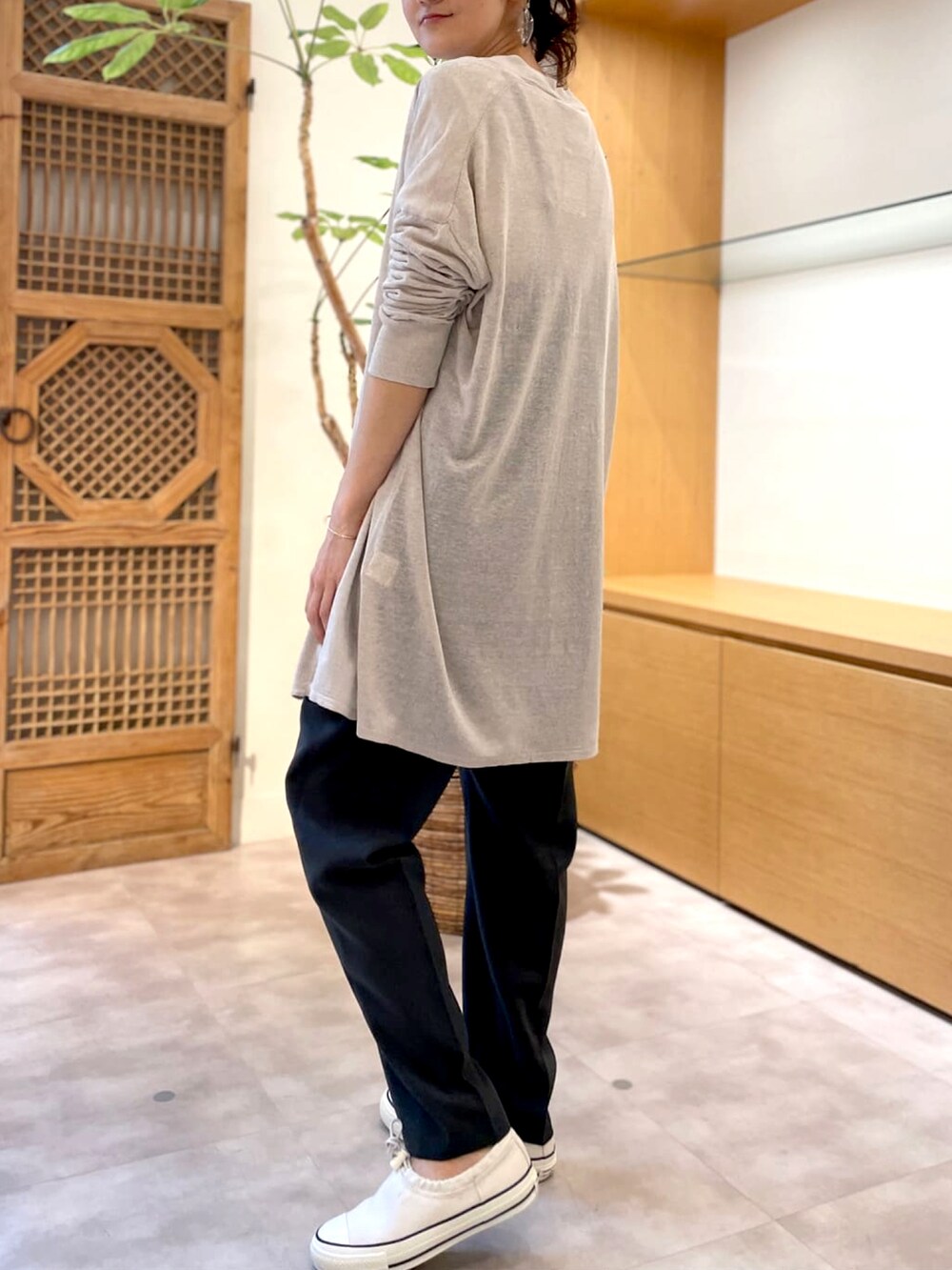 ベージュ系のカーディガン/ボレロ、グレー系のワンピース、ホワイト系のTシャツ/カットソーを着用したレディースの春コーディネートの2枚目の写真