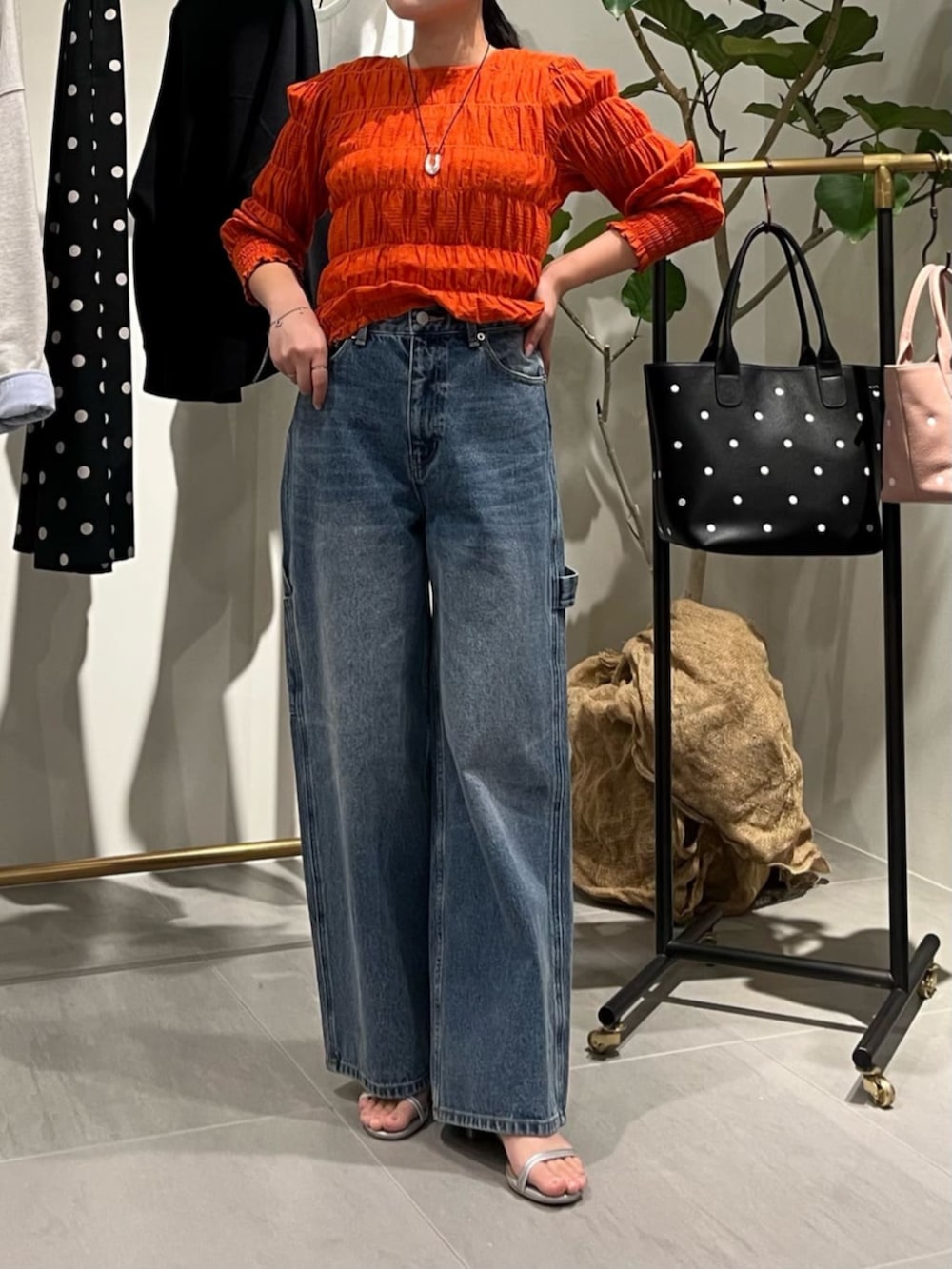 オレンジ系のシャツ/ブラウス、ブラウン系のトートバッグ、ブルー系のその他パンツを着用したレディースの春コーディネートの3枚目の写真