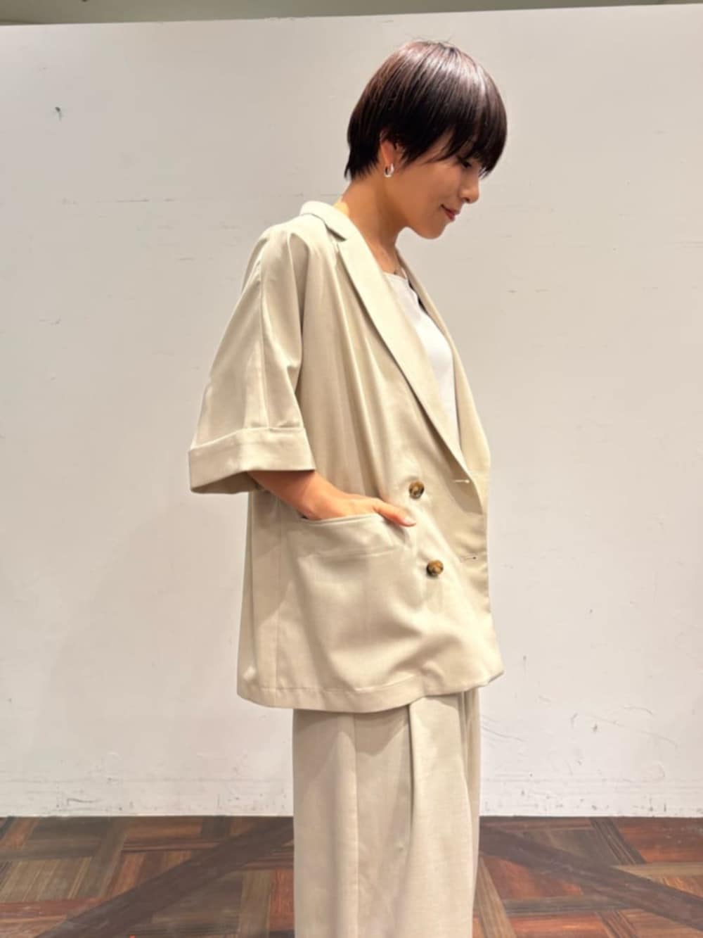 ブラック系のハンドバッグ、ベージュ系のテーラードジャケット、ベージュ系のその他パンツを着用したレディースの春コーディネートの4枚目の写真