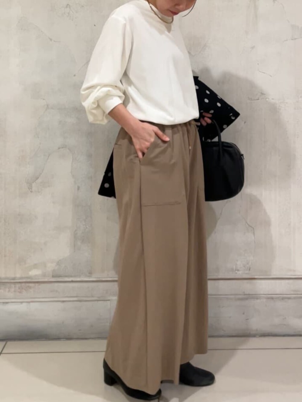 ホワイト系のシャツ/ブラウス、ブラック系のその他アウター、ベージュ系のその他パンツを着用したレディースの冬コーディネートの5枚目の写真