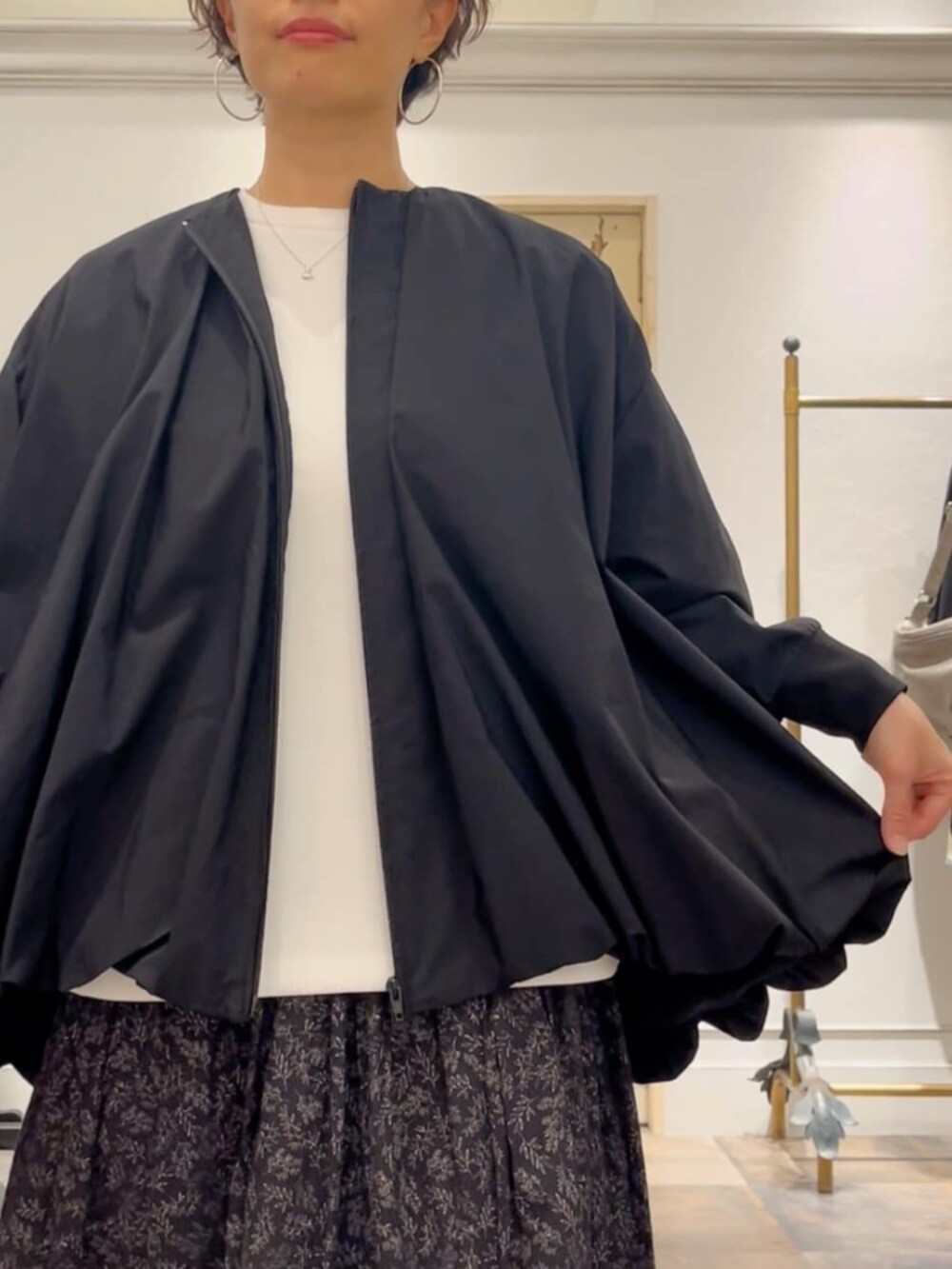 ブラック系のスカート、ベージュ系のショルダーバッグ、ブラック系のブルゾンを着用したレディースの冬コーディネートの4枚目の写真