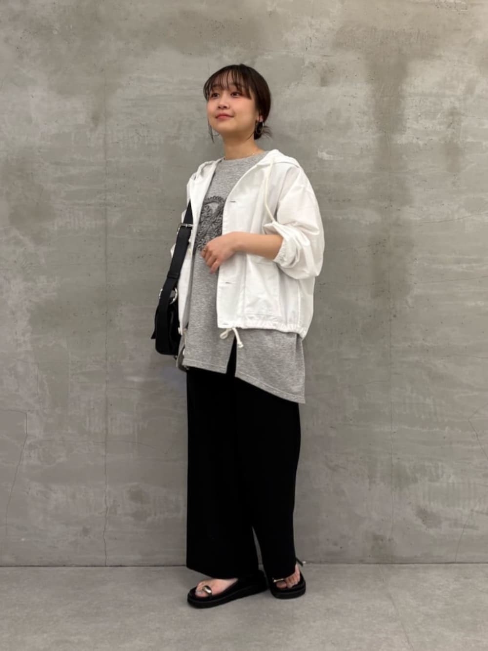 ブラック系のショルダーバッグ、ブラック系のサンダル、ホワイト系のシャツ/ブラウスを着用したレディースの冬コーディネートの2枚目の写真